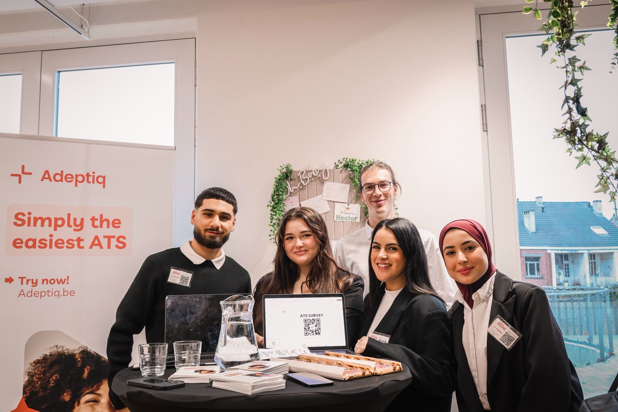 A group of students in front of an Adeptiq banner