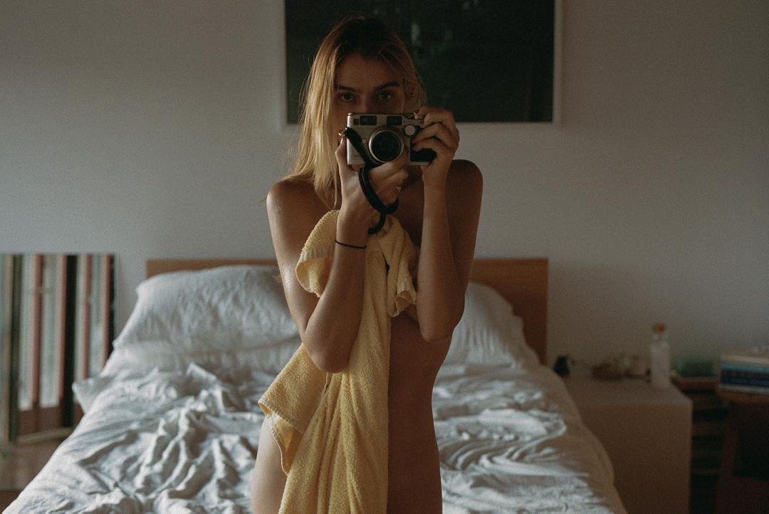 girl taking picture on bed