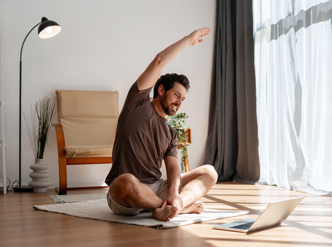man doing light stretching at home on his floor as recovery for his walking program to lose weight