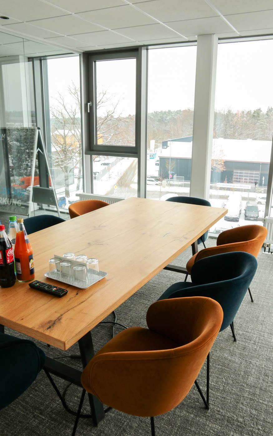 Besprechungsraum bei rankk mit großem Tisch, acht Stühlen und einer großen Fensterfront.