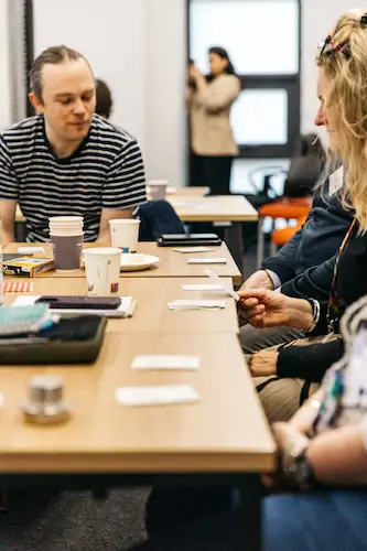 People sitting around a table with papers and laptops.