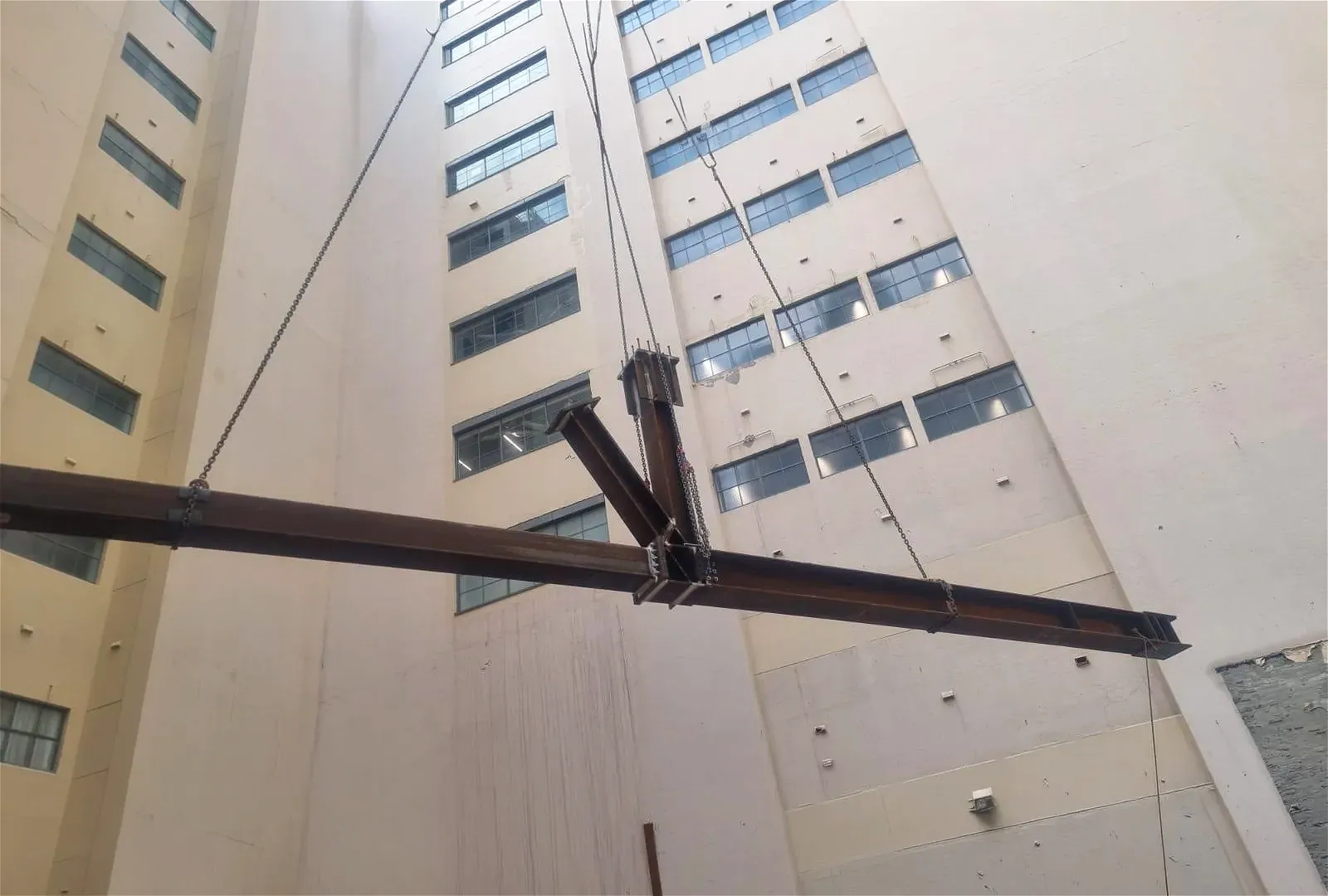 Steel beam construction with chains and building.