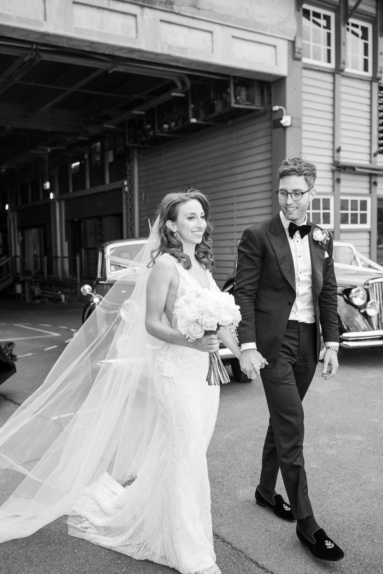 Candid wedding moment – groom whispering something to laughing bride outdoors