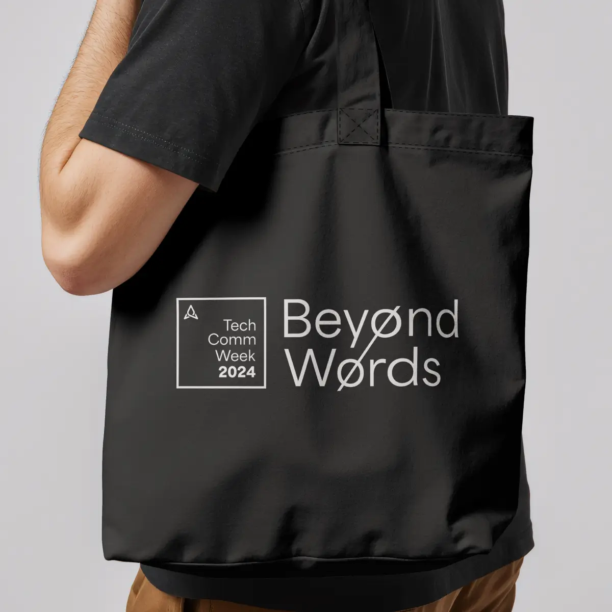 A person carries a black tote bag with white text reading "Tech Comm Week 2024" and "Beyond Words." The style is modern and tech-focused.
