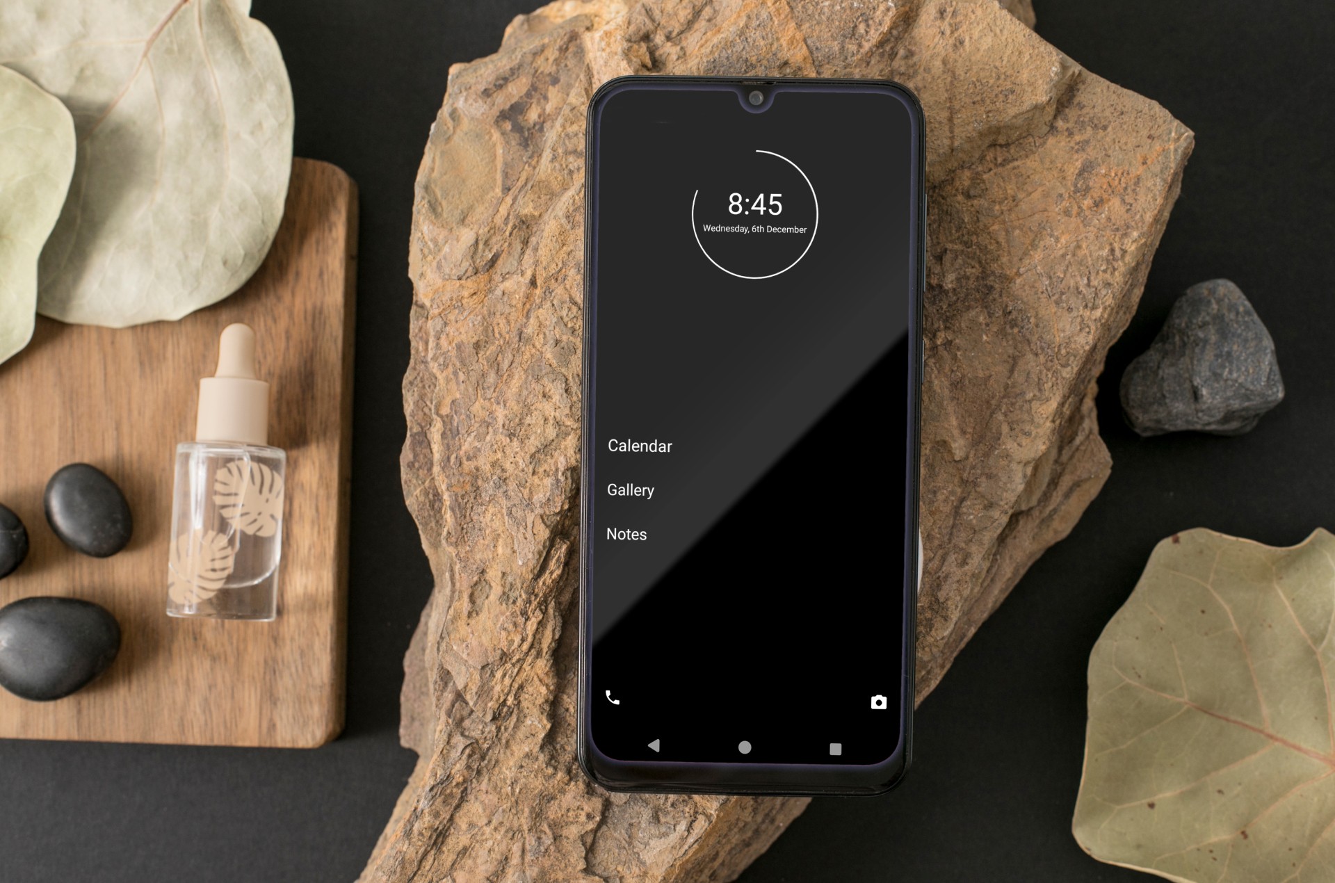 Smartphone with minimalist phone interface on natural stones.