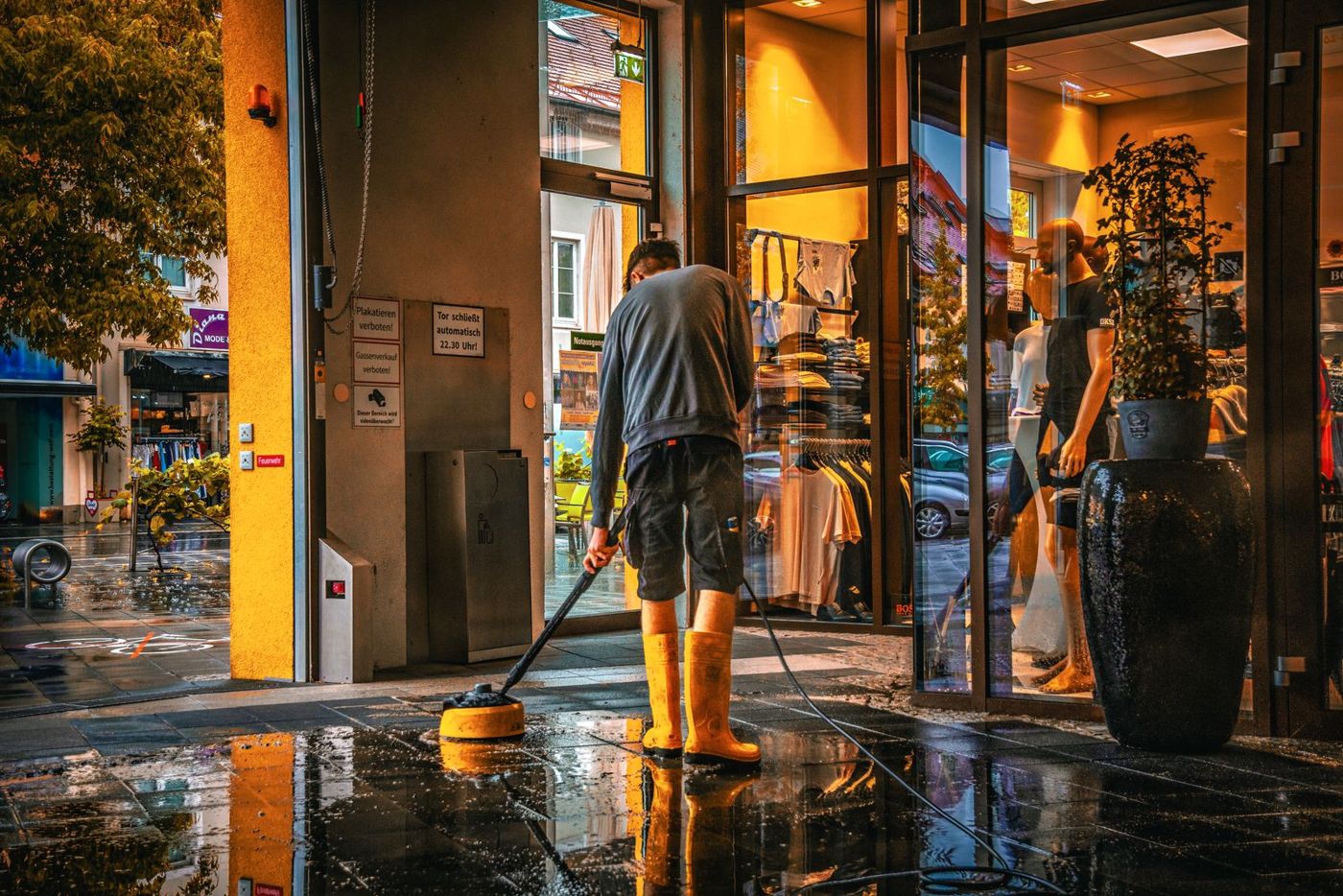 Worker mopping the entrance of a retail shop