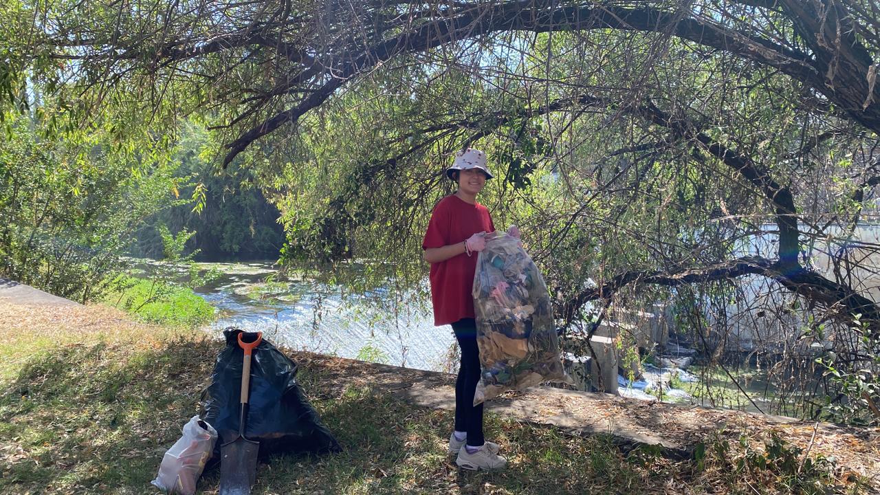 Judith collecting trash to cleanup the environment