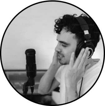 A singer, wearing headphones, is immersed in a music jam session, passionately signing into a microphone.