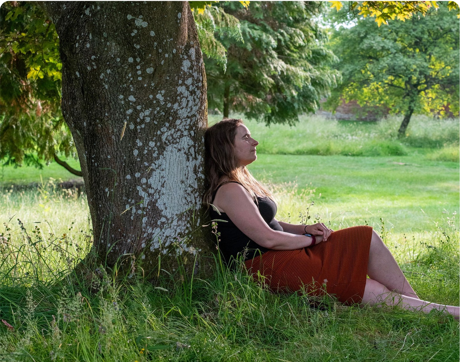 image of Seiran, an unpaid carer who looks after her son, resting in the grass