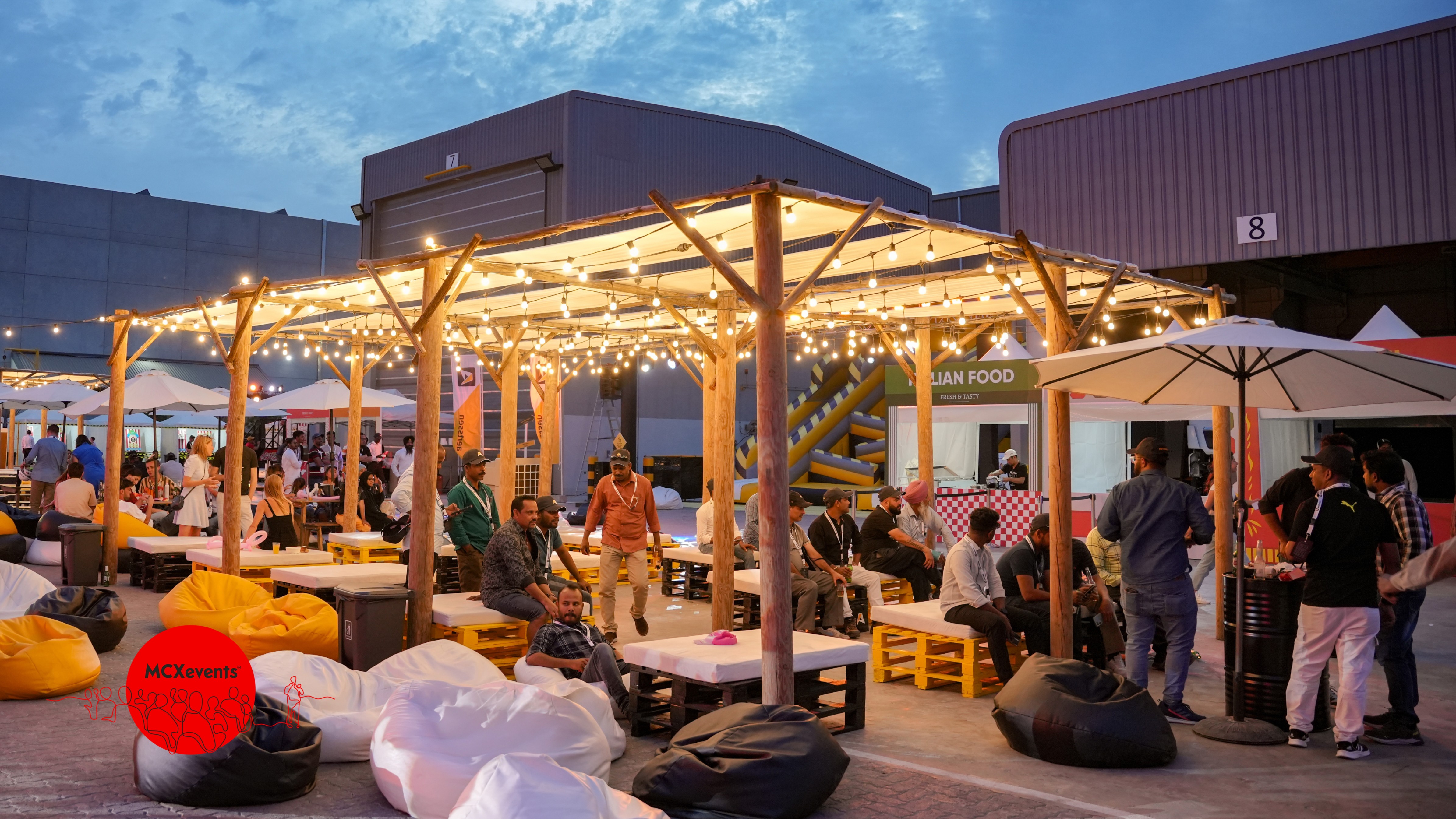 Mature man with glasses and a trimmed beard smiling confidently, standing in warm natural light against a modern backdrop.