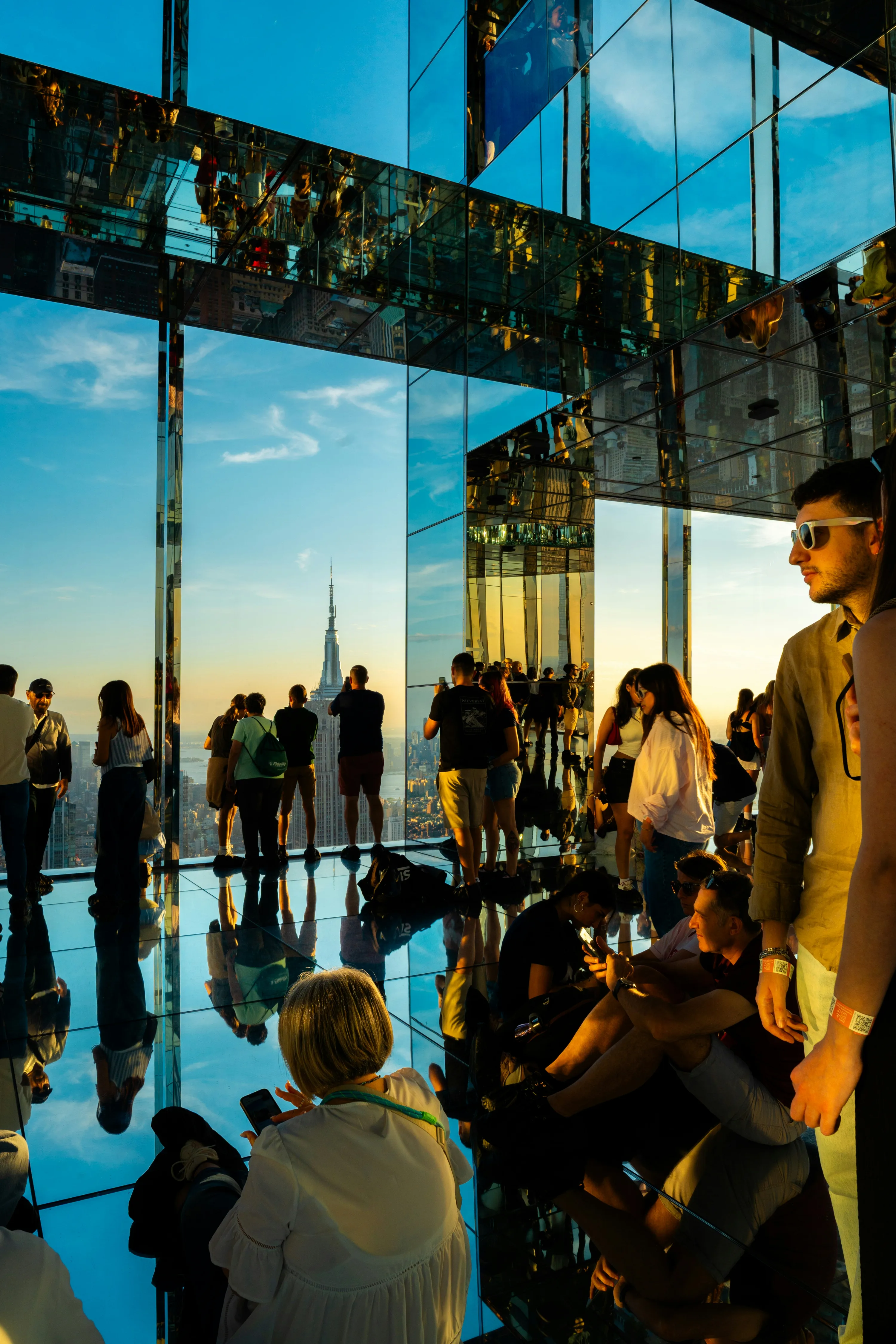 The observation deck at the top of the SUMMIT One Vanderbilt Observatory in New York City, featuring mirrored floors and a fiew of the Empire State Building.