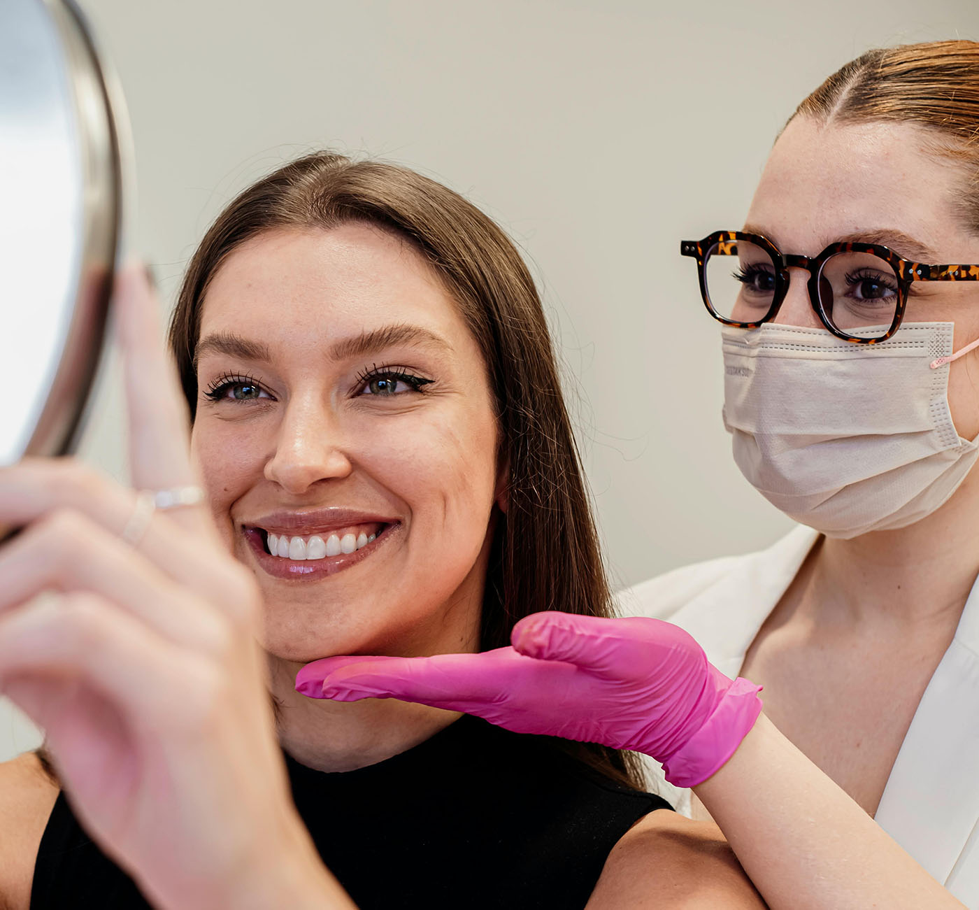 A women looking in the mirror after medical grade aesthetics treatment including lip filler