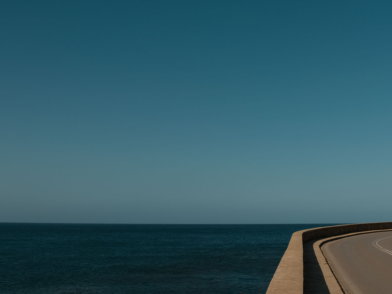 a road, the sea, and a clear horizon
