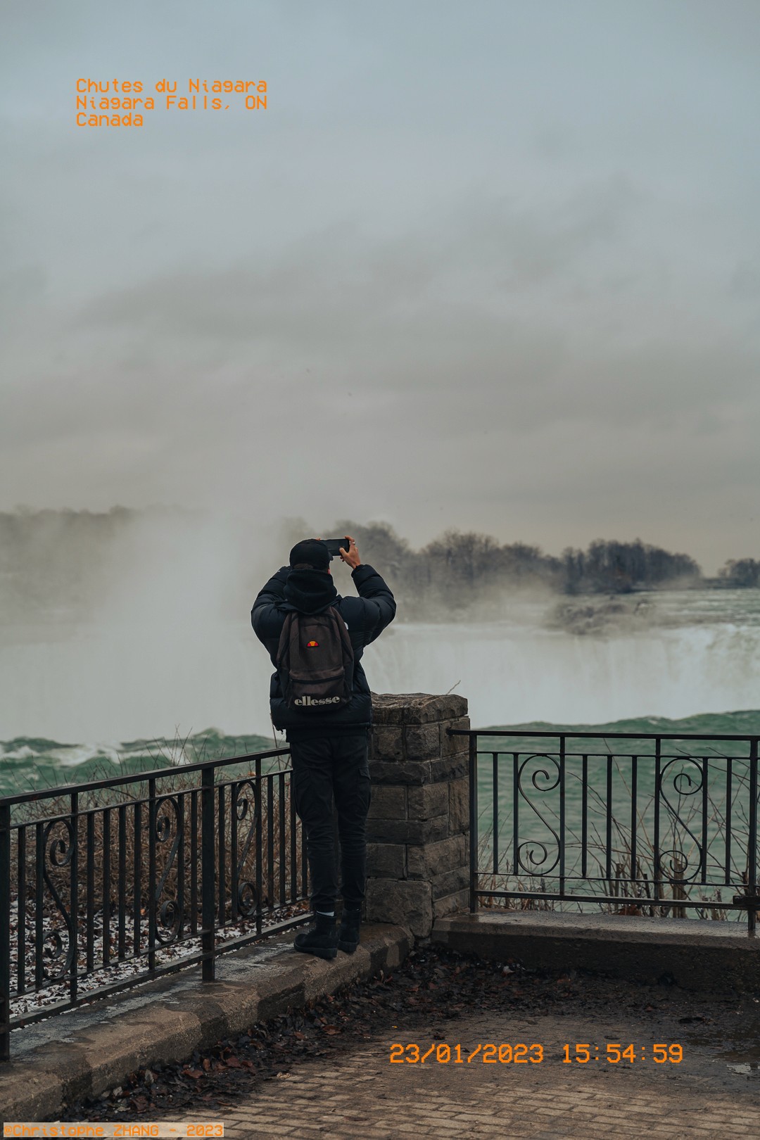 Visiteur capturant la vue des chutes du Niagara un jour brumeux de janvier.