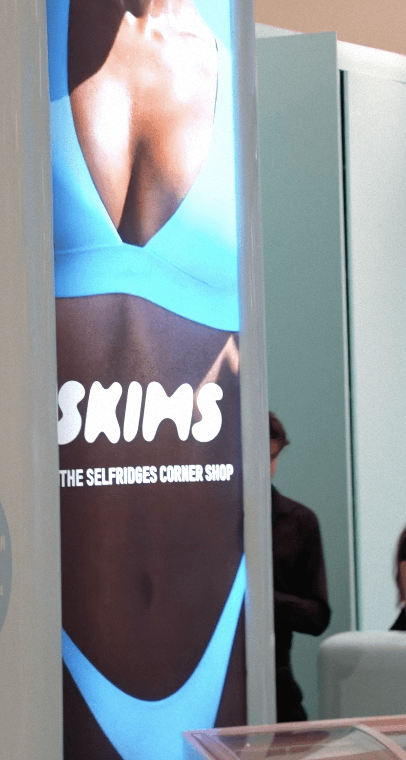 Bride in white dress walking on street, man in background