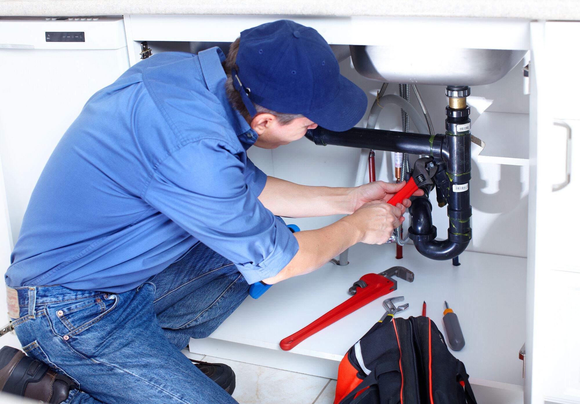 Plumber working under a sink.