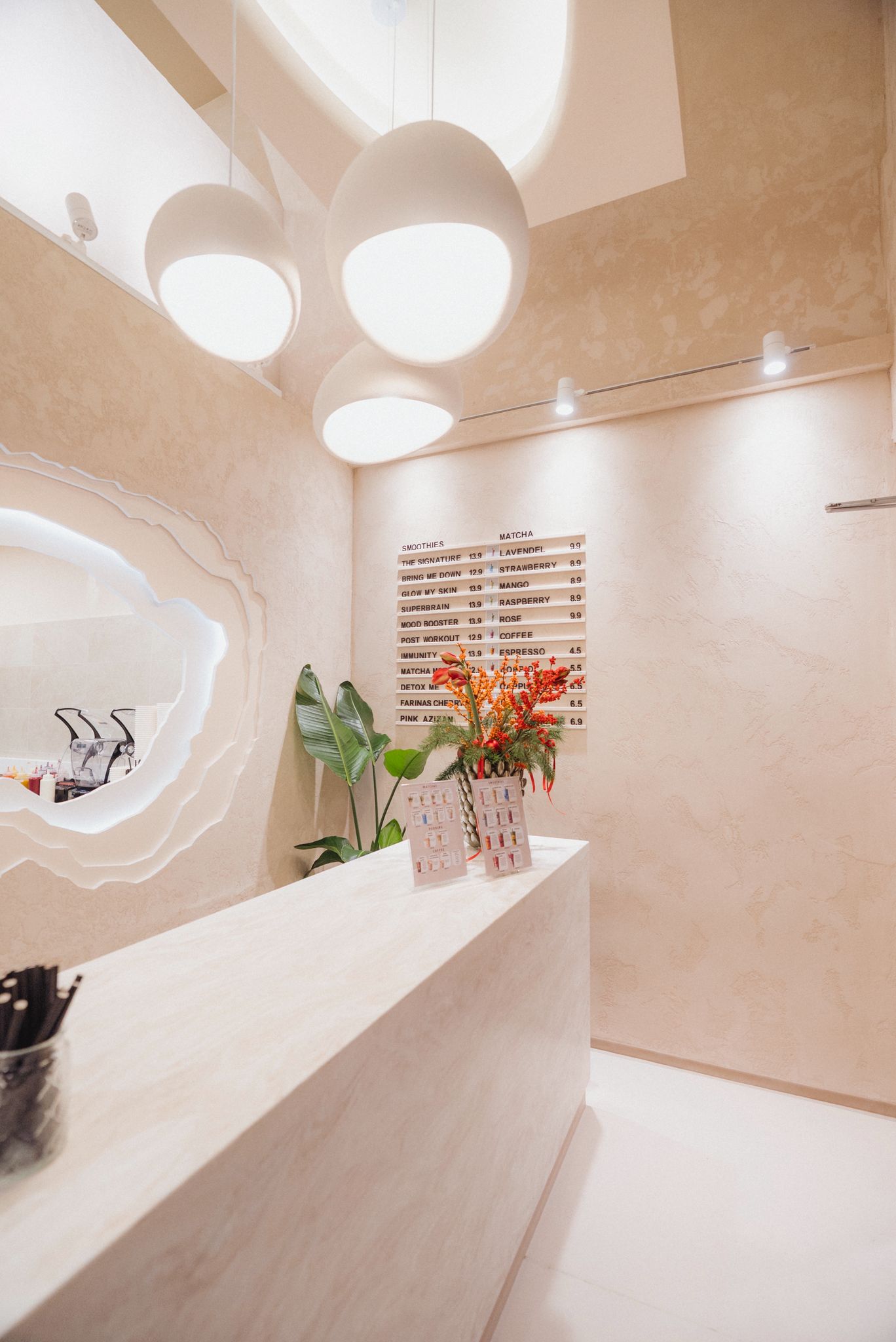 Two people talking at table in plant-filled café