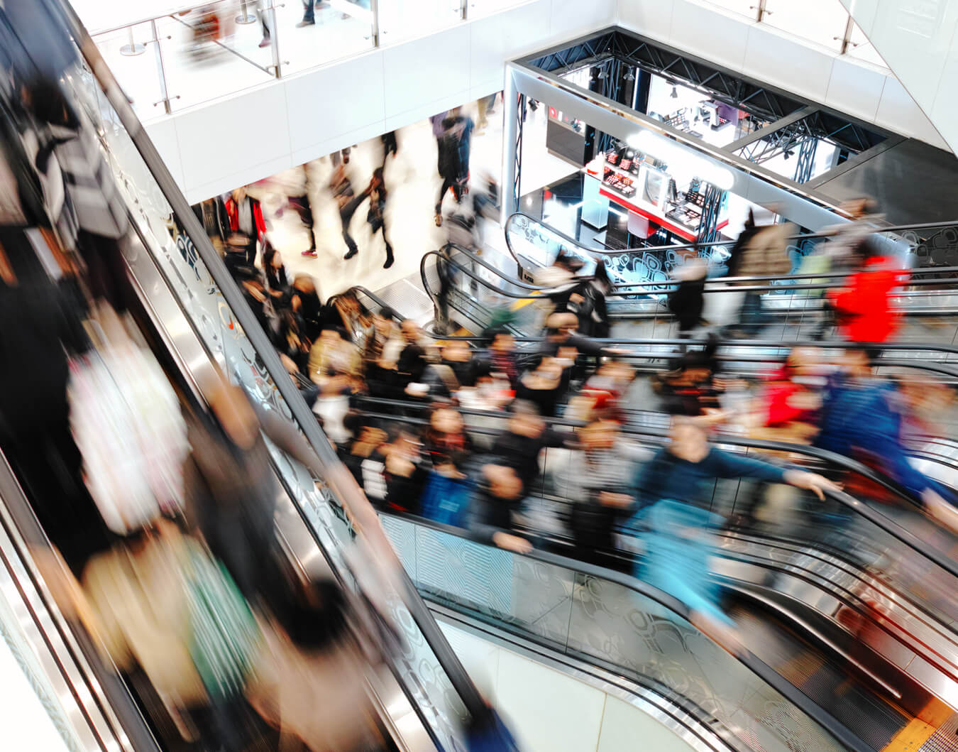 Crowded shopping mall with people on escalators