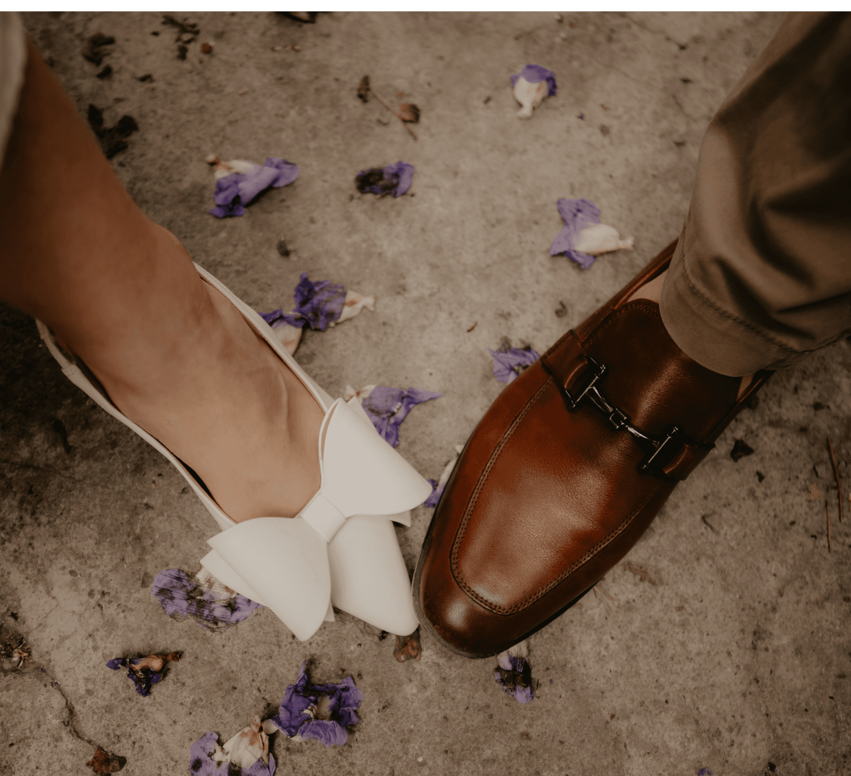 A bride and groom share a kiss, enveloped in the bride's flowing veil. The soft focus and gentle light convey a romantic, intimate atmosphere.