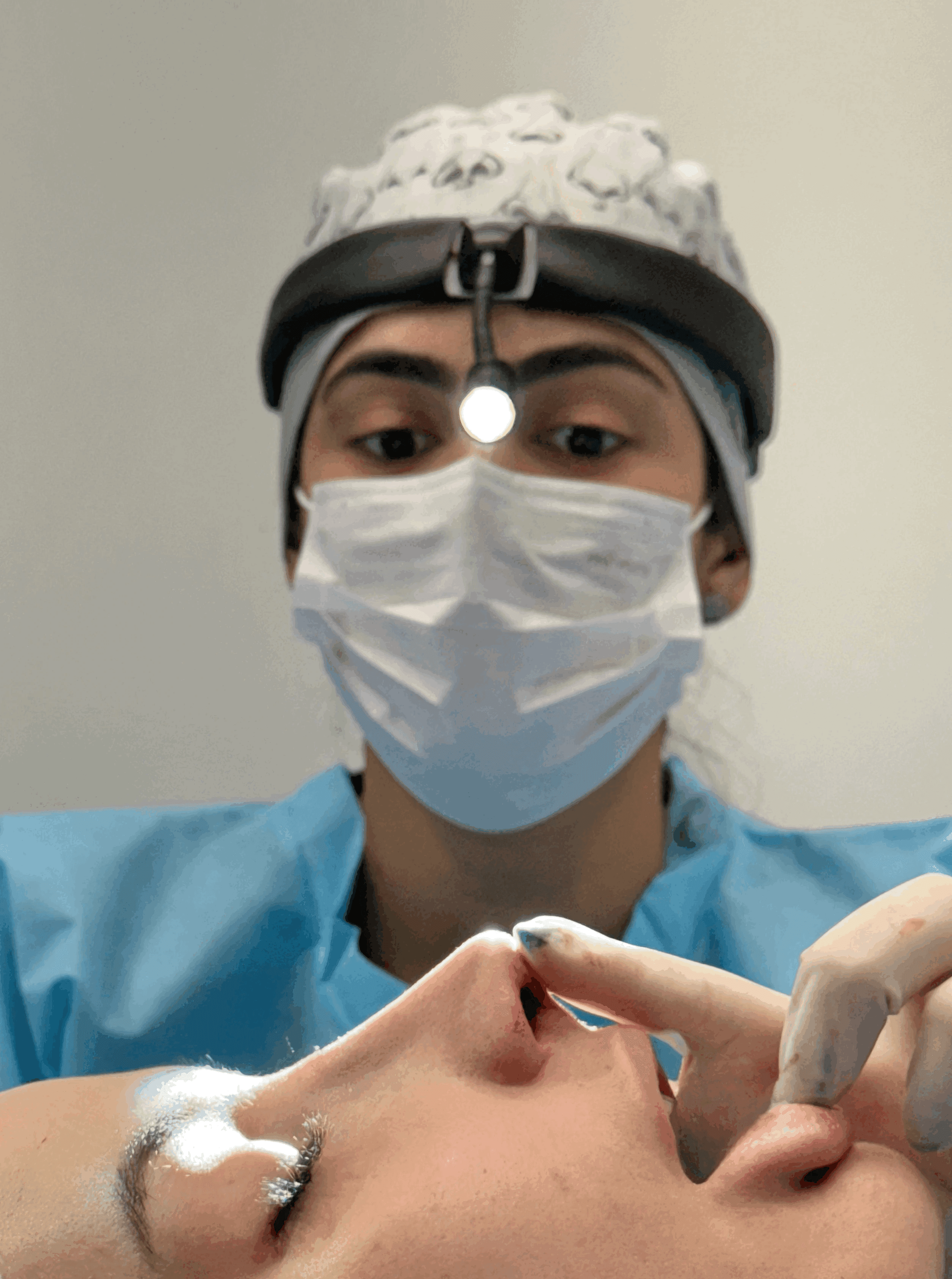 A person with curly hair sits at a desk, working on a laptop in a cozy, well-lit environment.