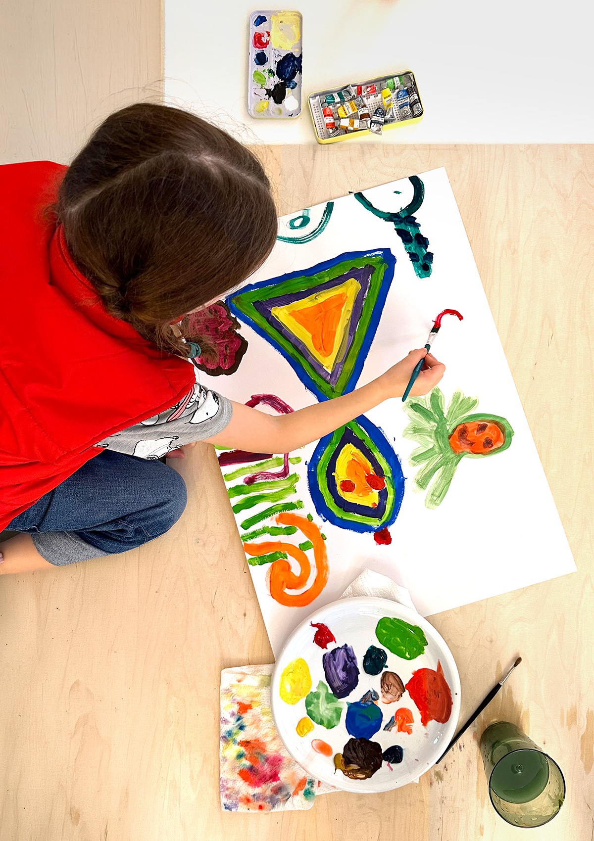 Kind malt bunte geometrische Muster mit Wasserfarben im Malkurs