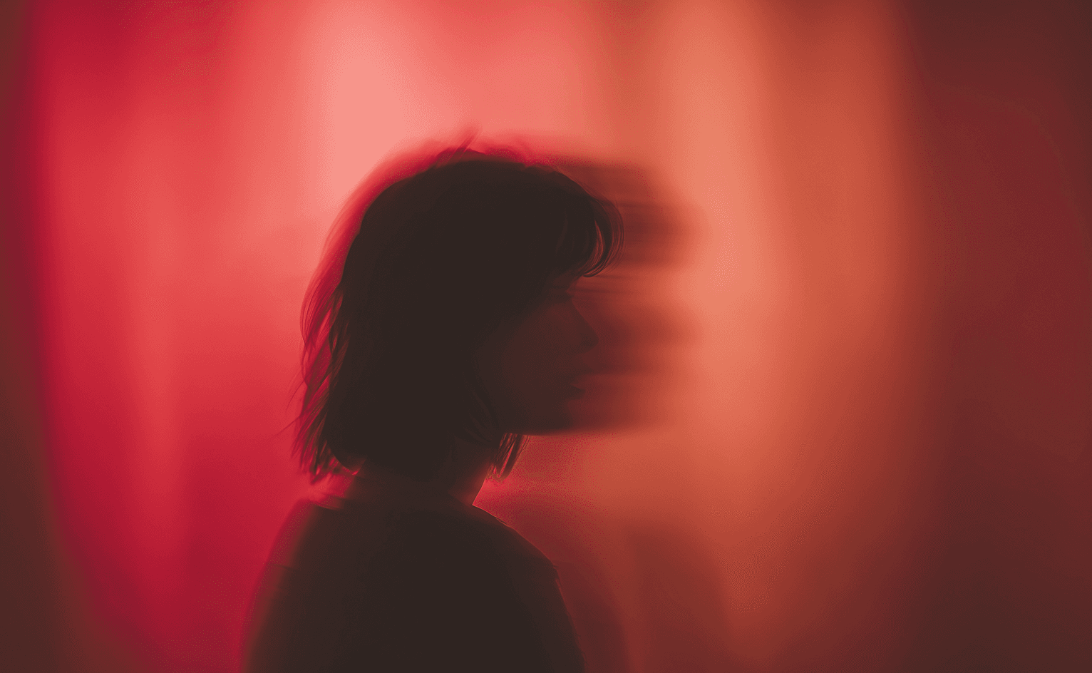 Silhouette against red background — dark mood visual direction reference