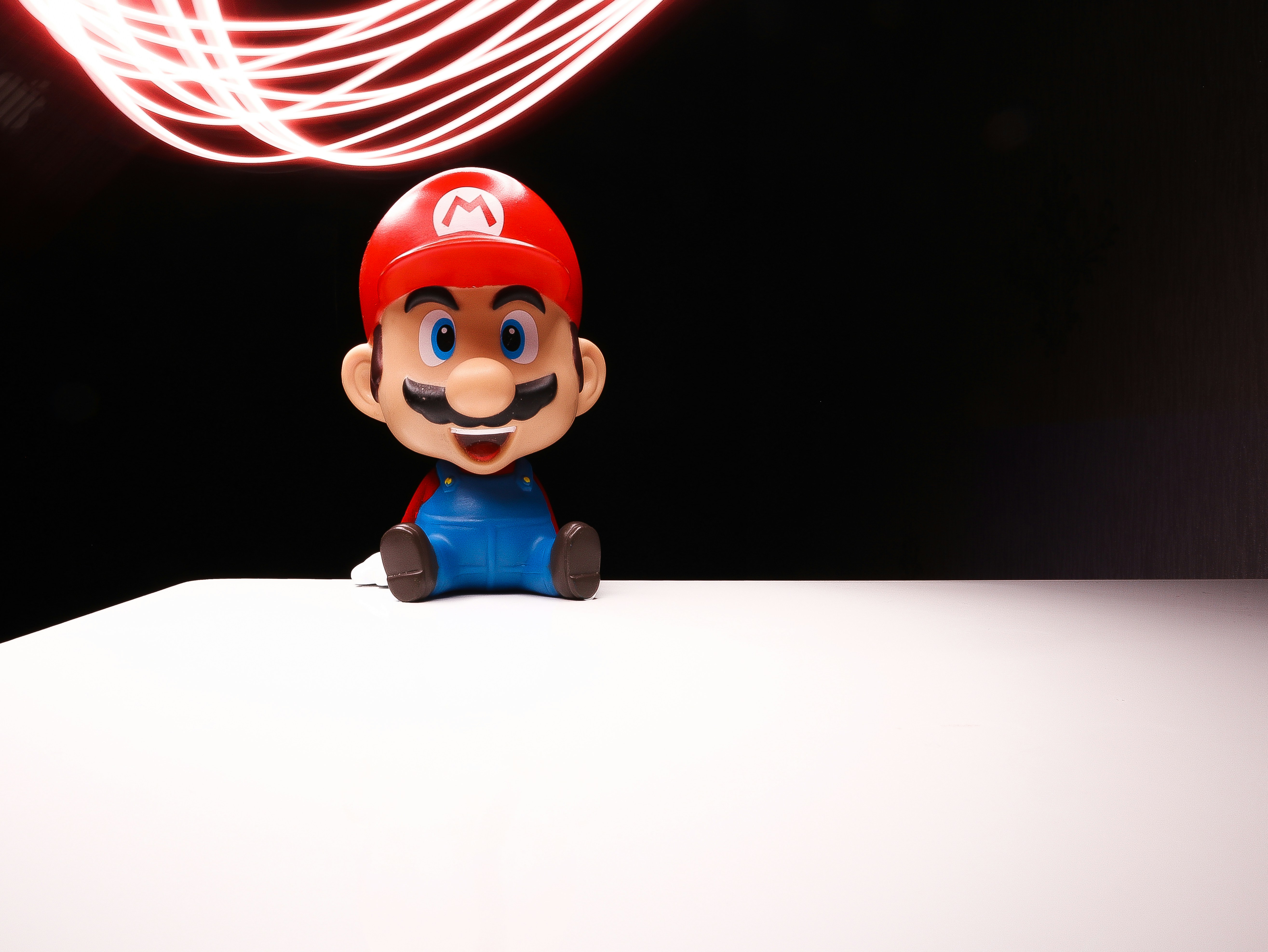 Small Mario figurine sitting under neon light streaks