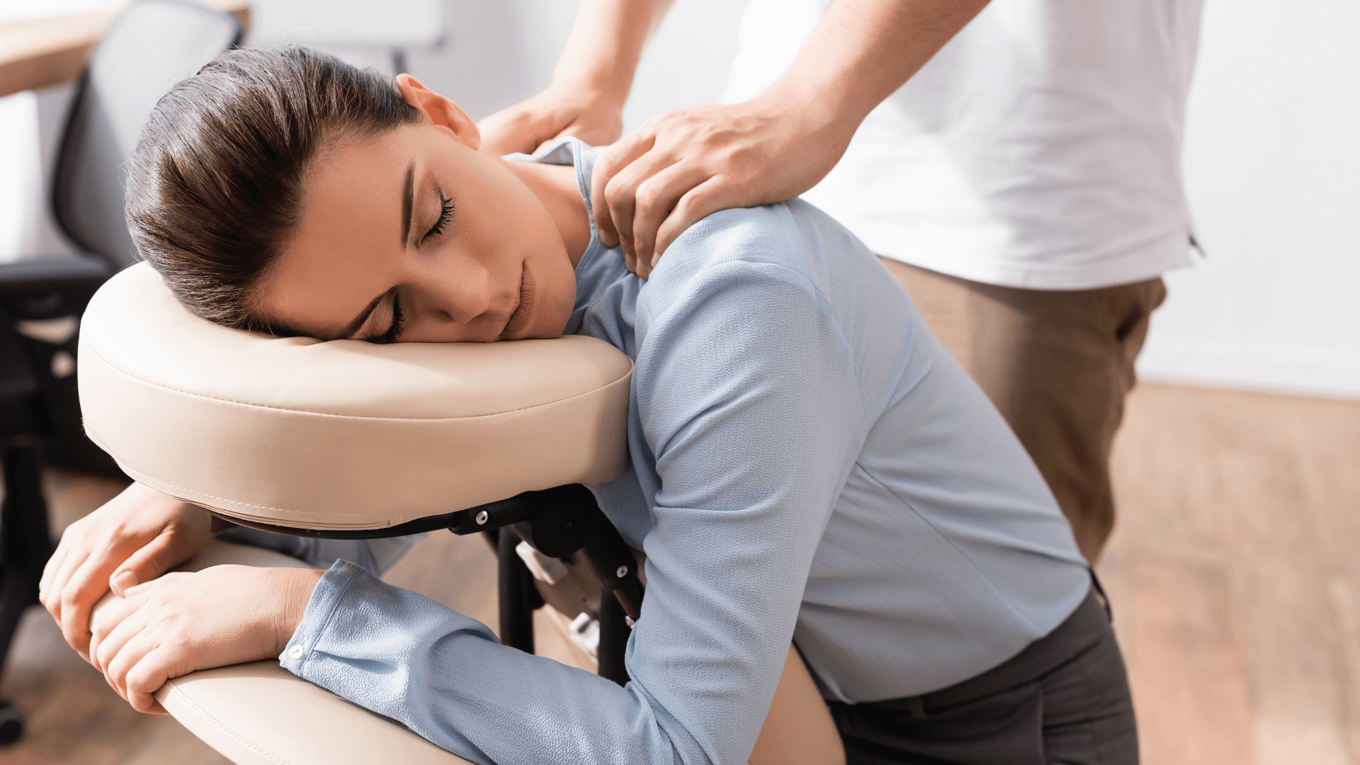 A winding road cuts through rocky terrain, surrounded by patches of green grass and illuminated by sunlight.