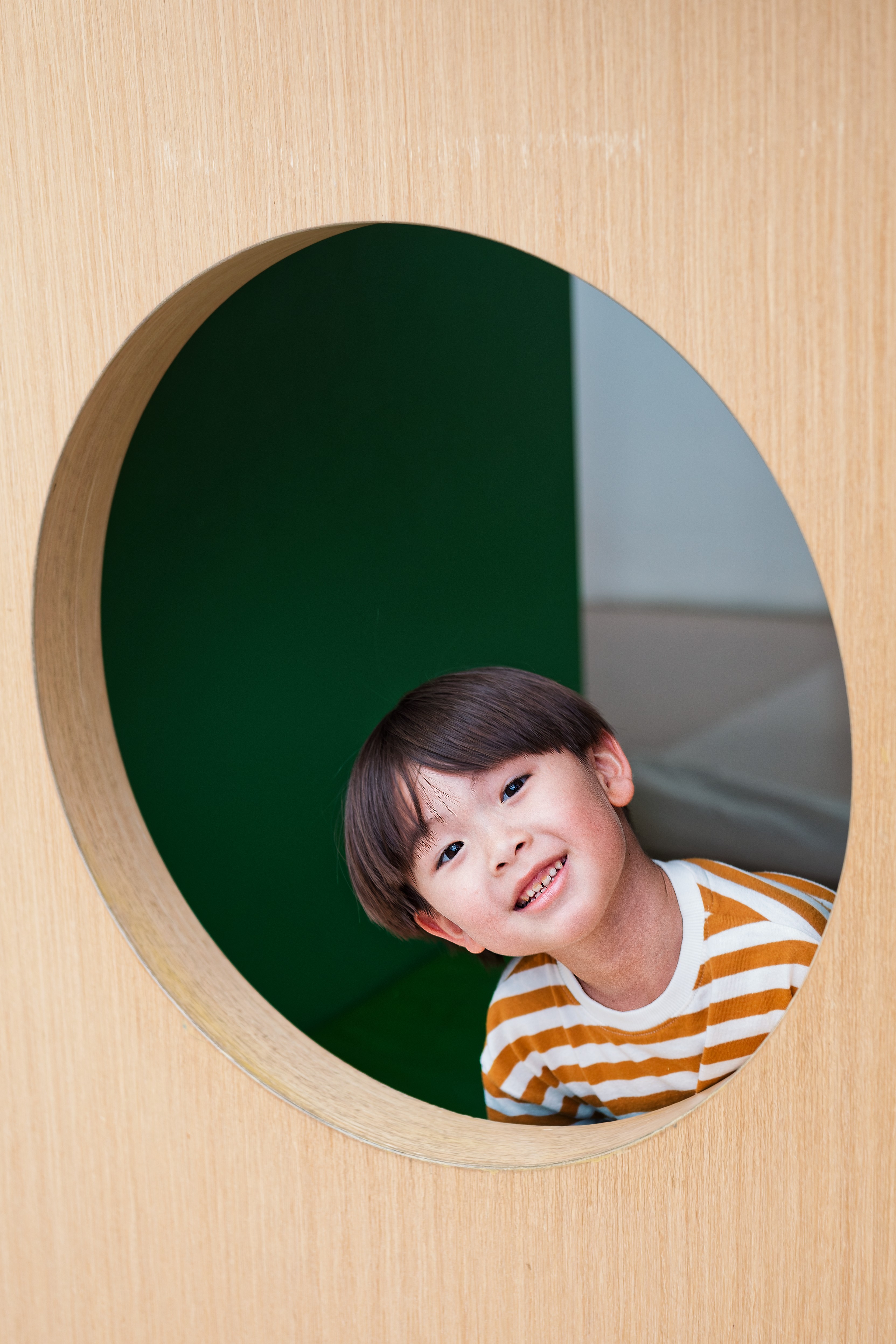 a child smiling through a circle hole