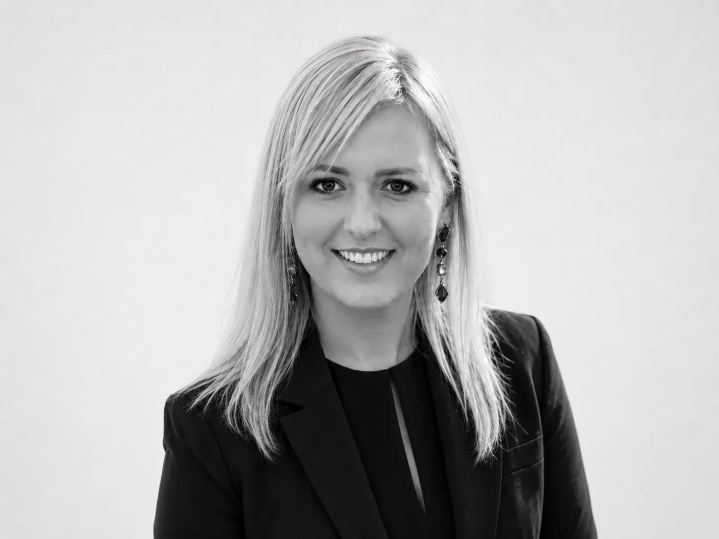 A woman in a business suit standing with her arms crossed