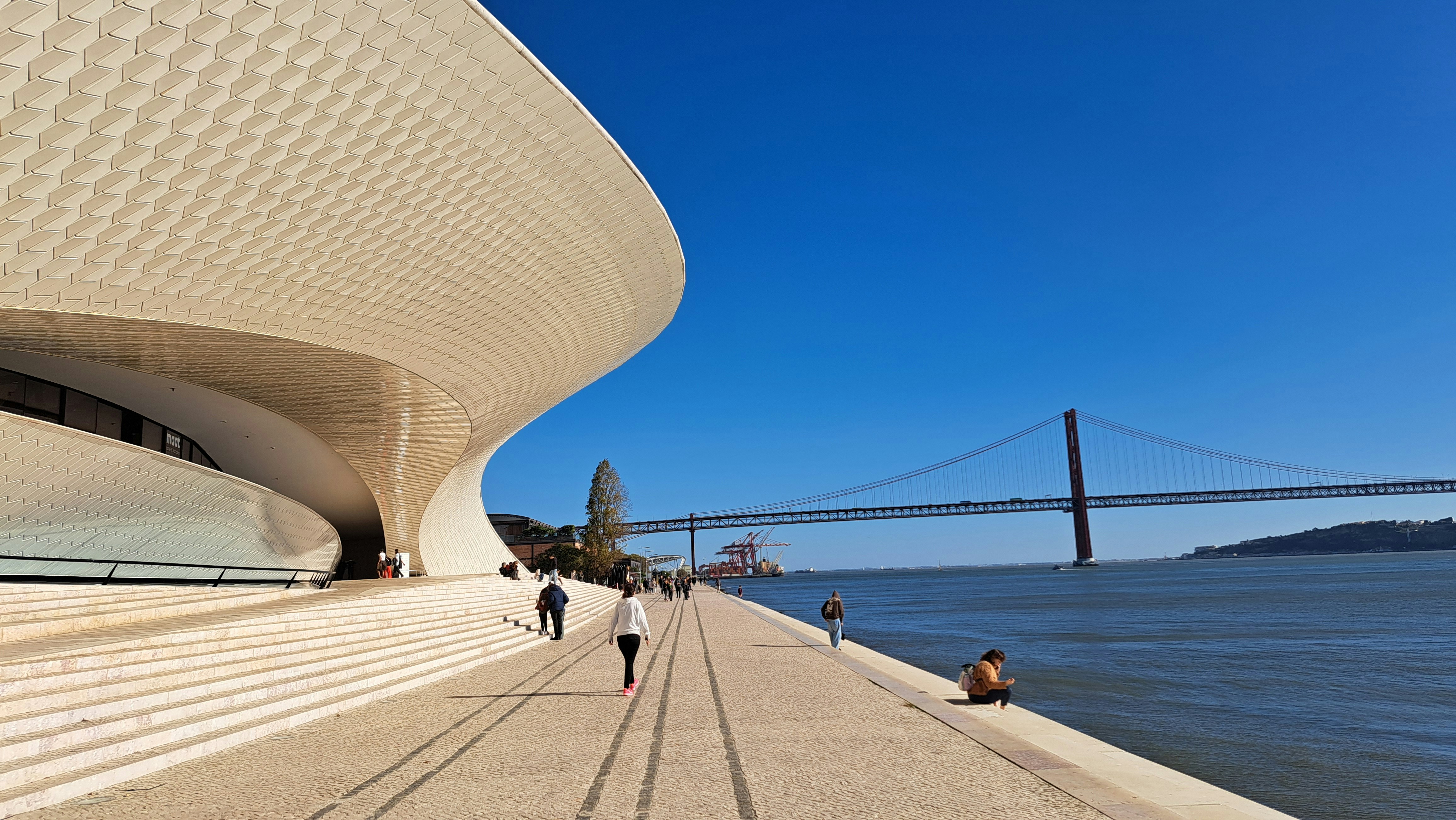 People walking on a walkway next to a body of water