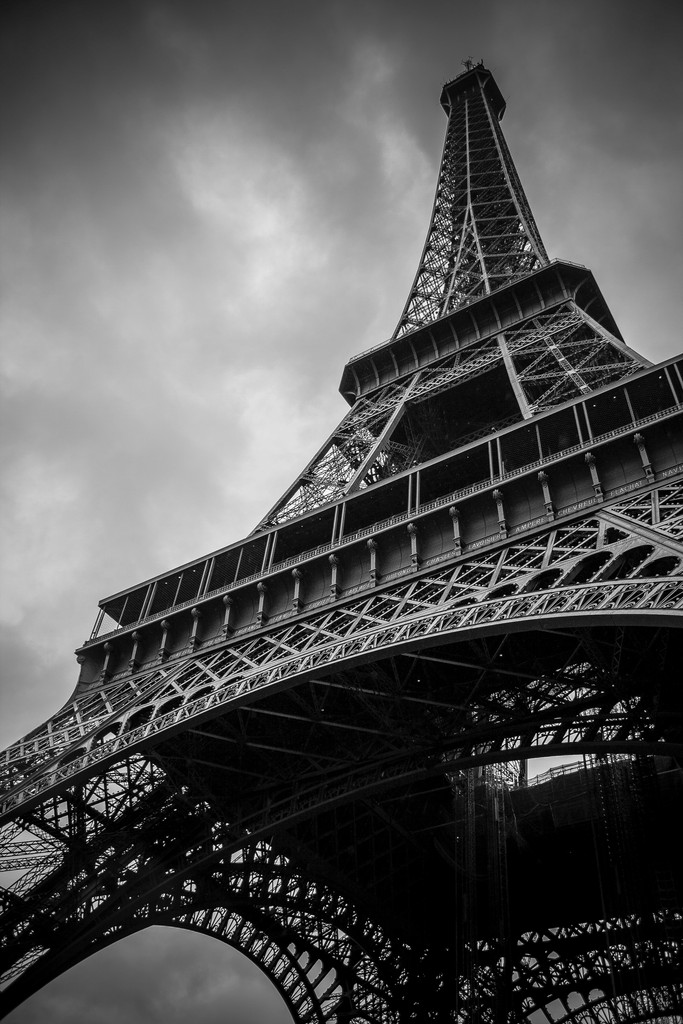 black white frog perspective taken underneath the eiffel tower showing the tower spear