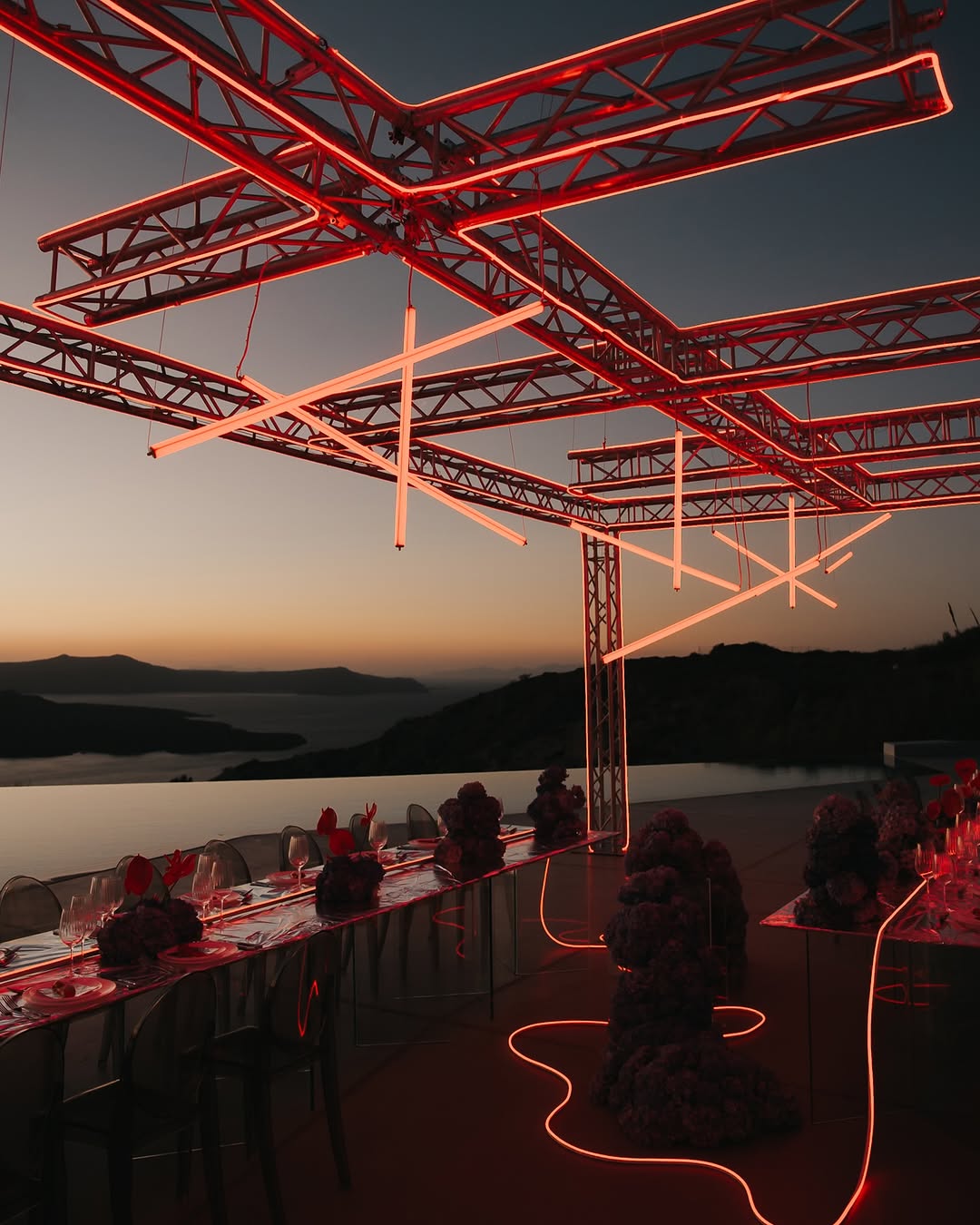 Modern rooftop terrace with red neon lines glowing at sunset — atmospheric and architectural.