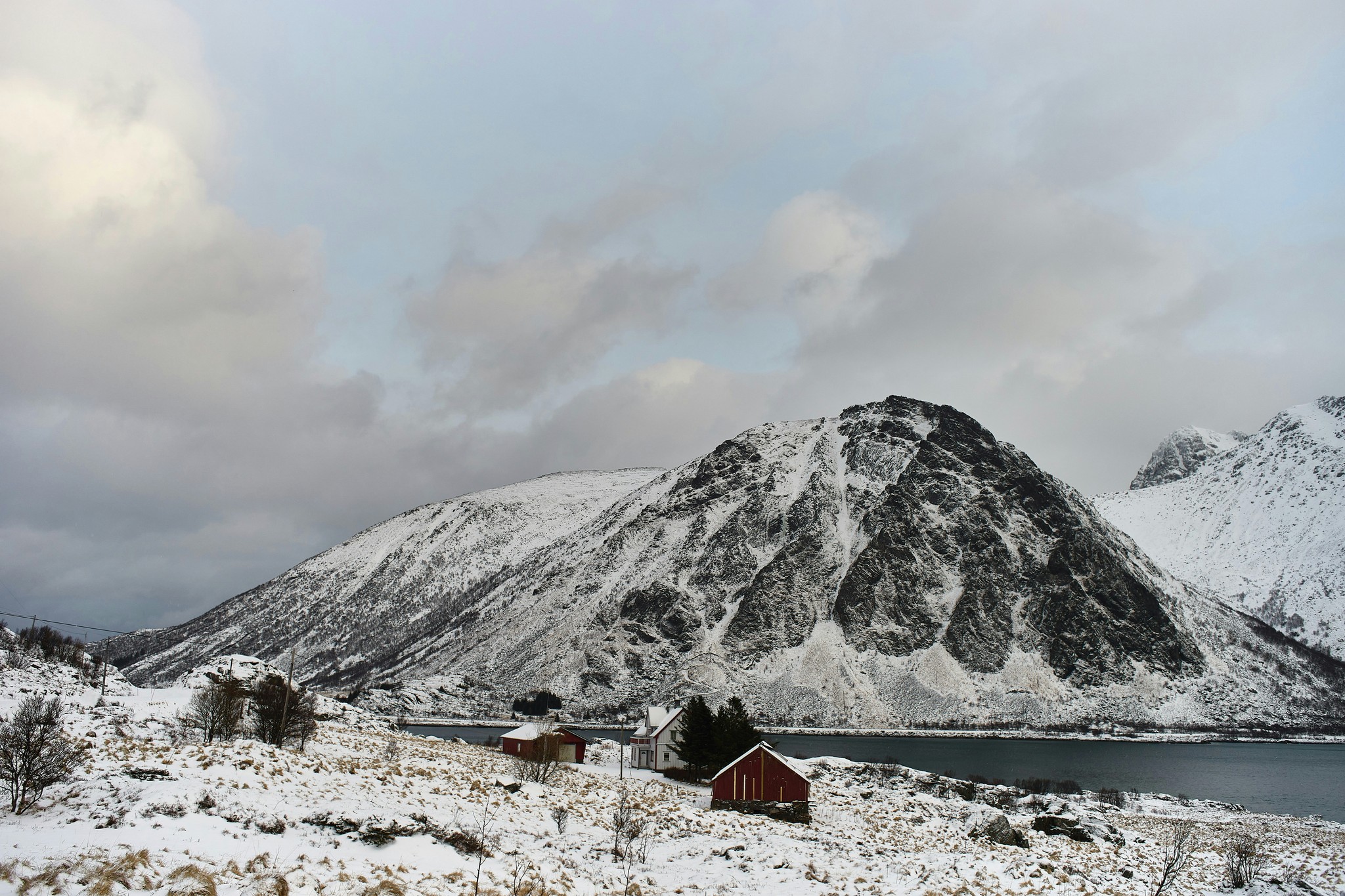 a snow covered mountain with a lake in the foreground