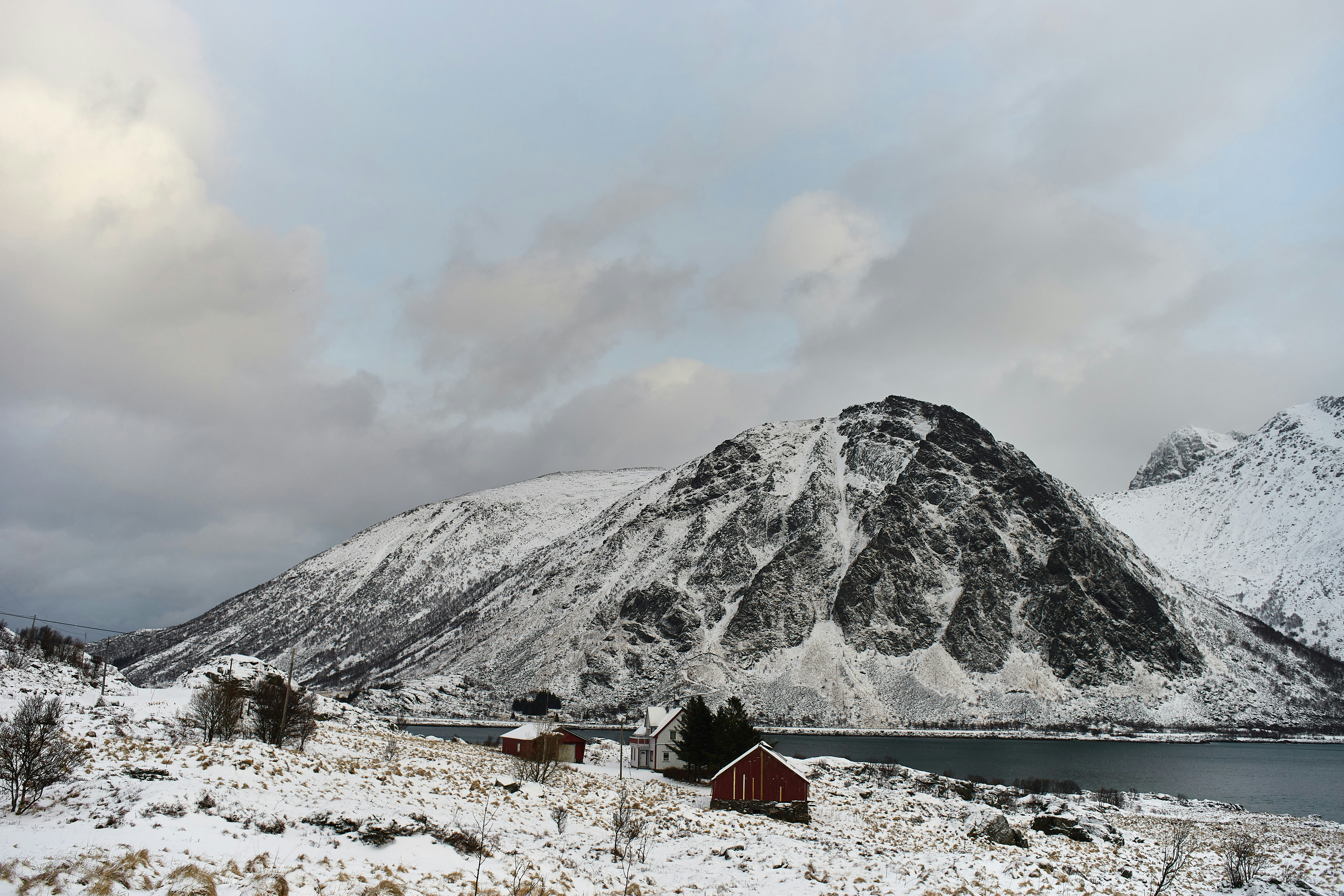 a snow covered mountain with a lake in the foreground