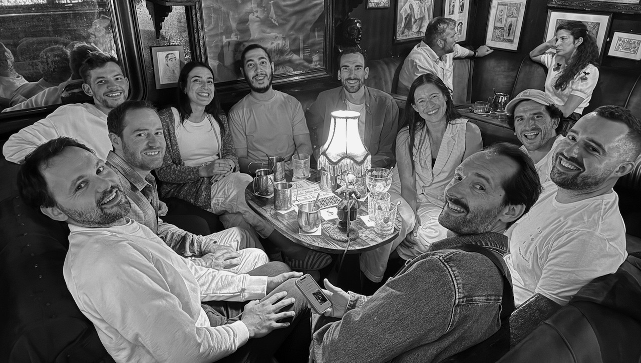 A screenshot of two GitBook team members working on laptops with mountains in the background