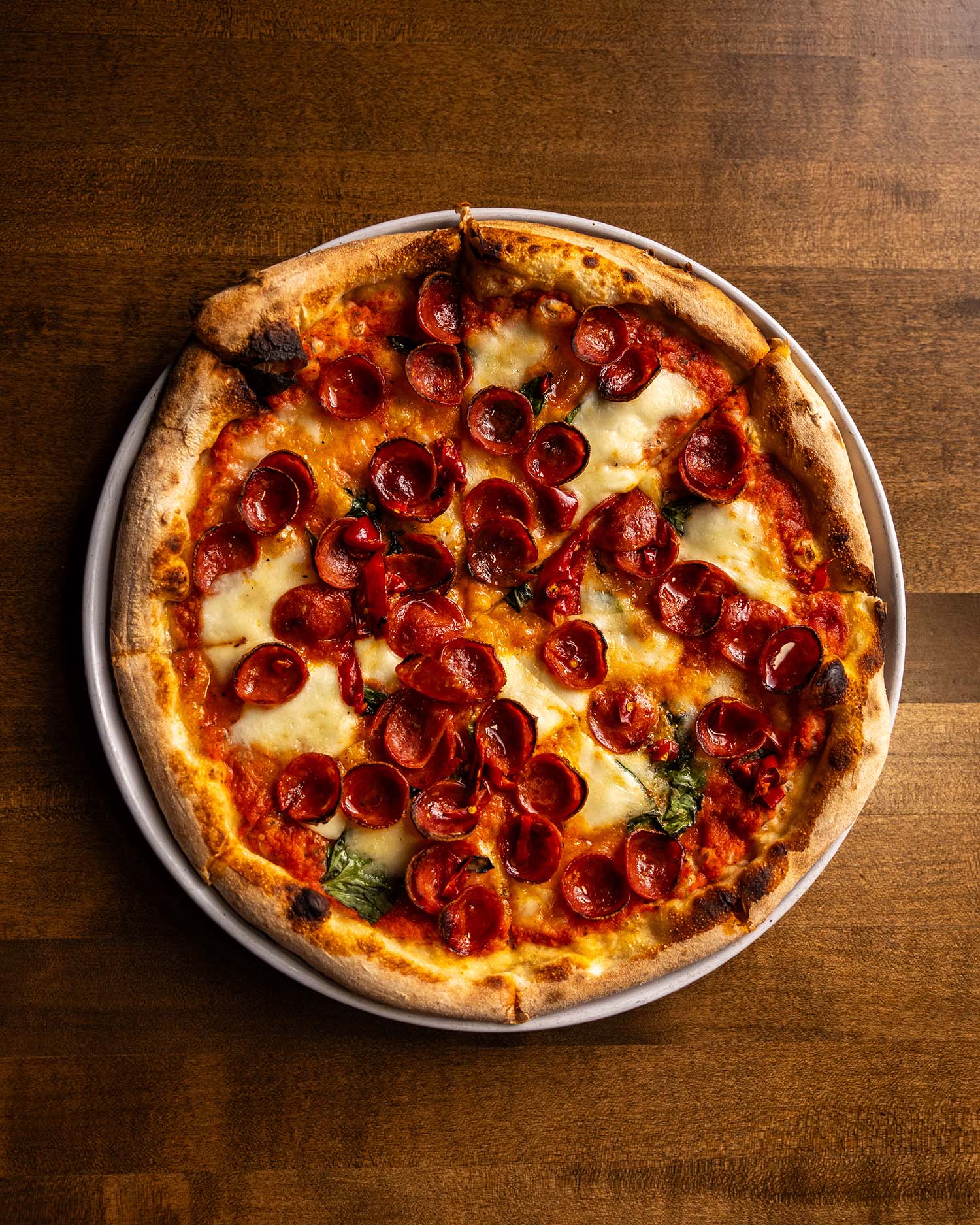 Wooden Paddle Pepperonly pizza with charred pepperoni cups overhead La Grange IL