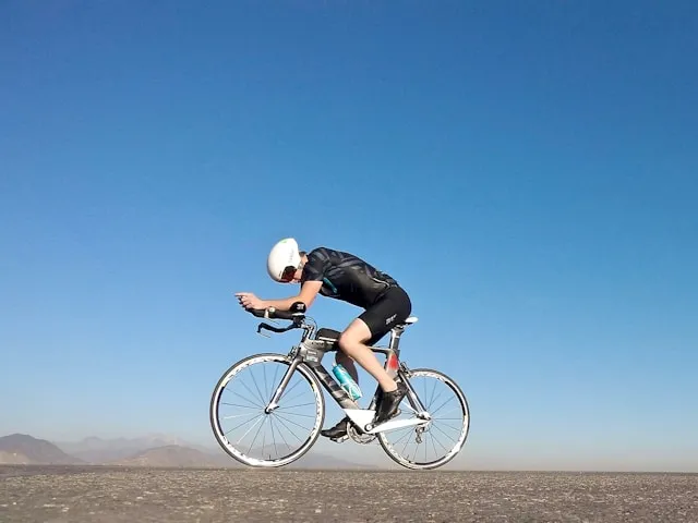 Cyclist riding on an open road, focused on effort and pacing