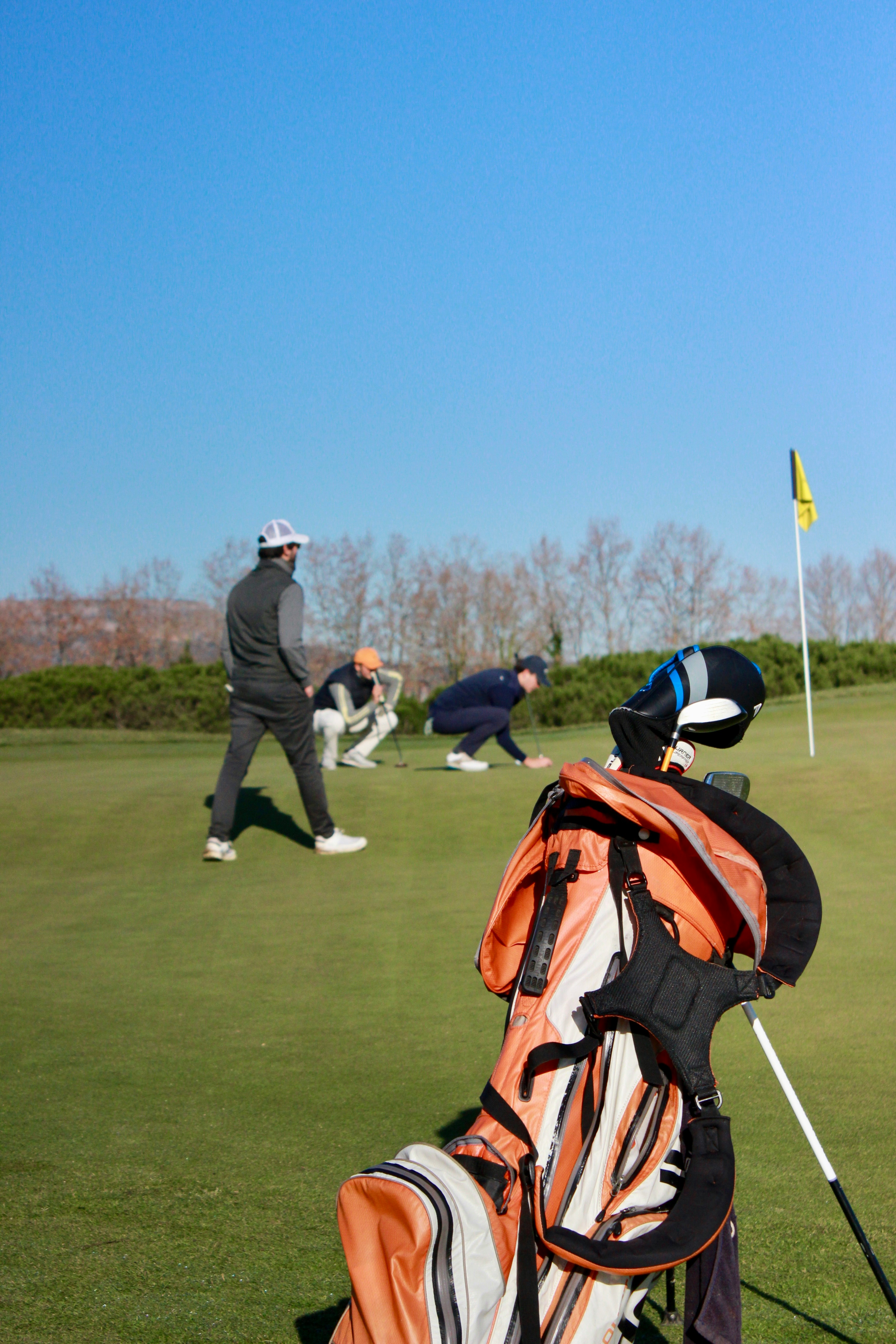 A man holding a golf club on top of a green