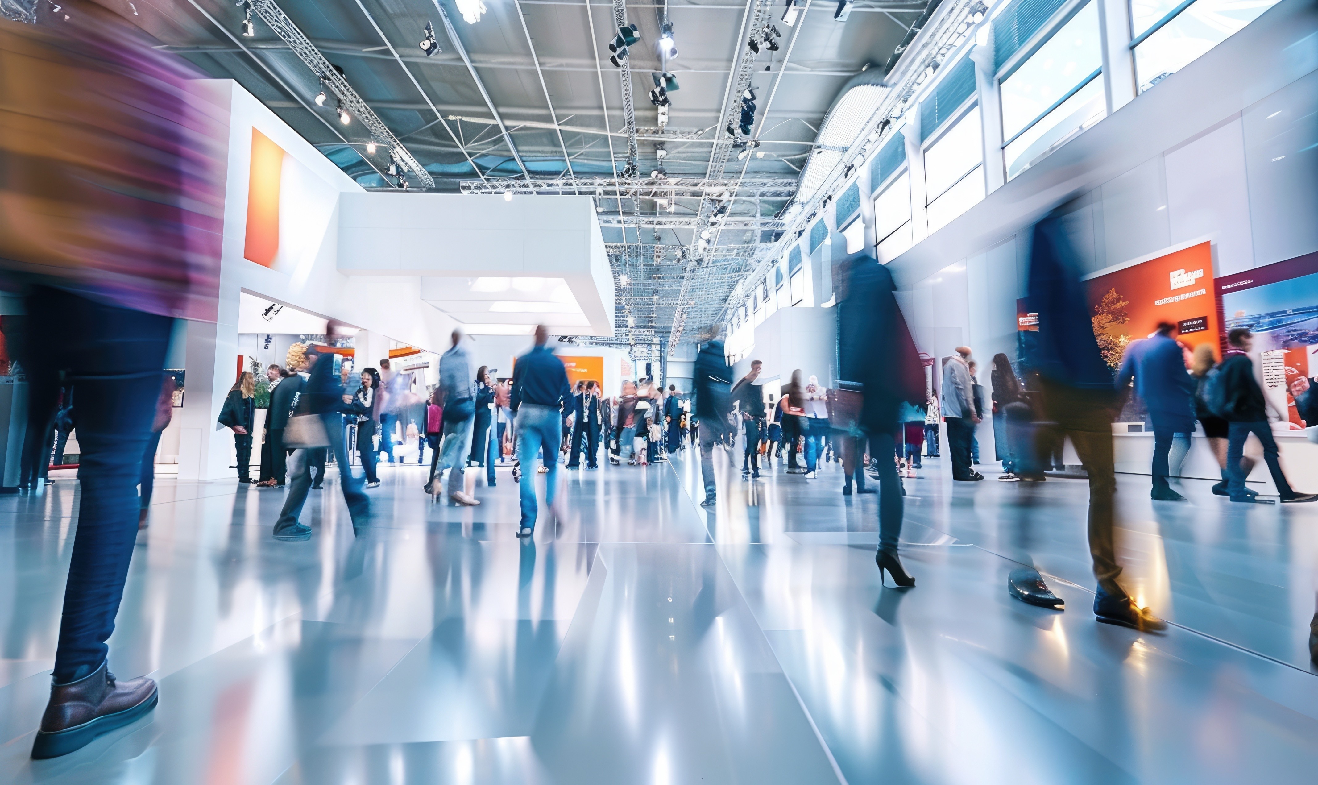 Blurred crowd walking through a bright trade show or convention hall, evoking the busy CES-style expo floor where new technology and tools are displayed but real strategy still depends on human decisions.