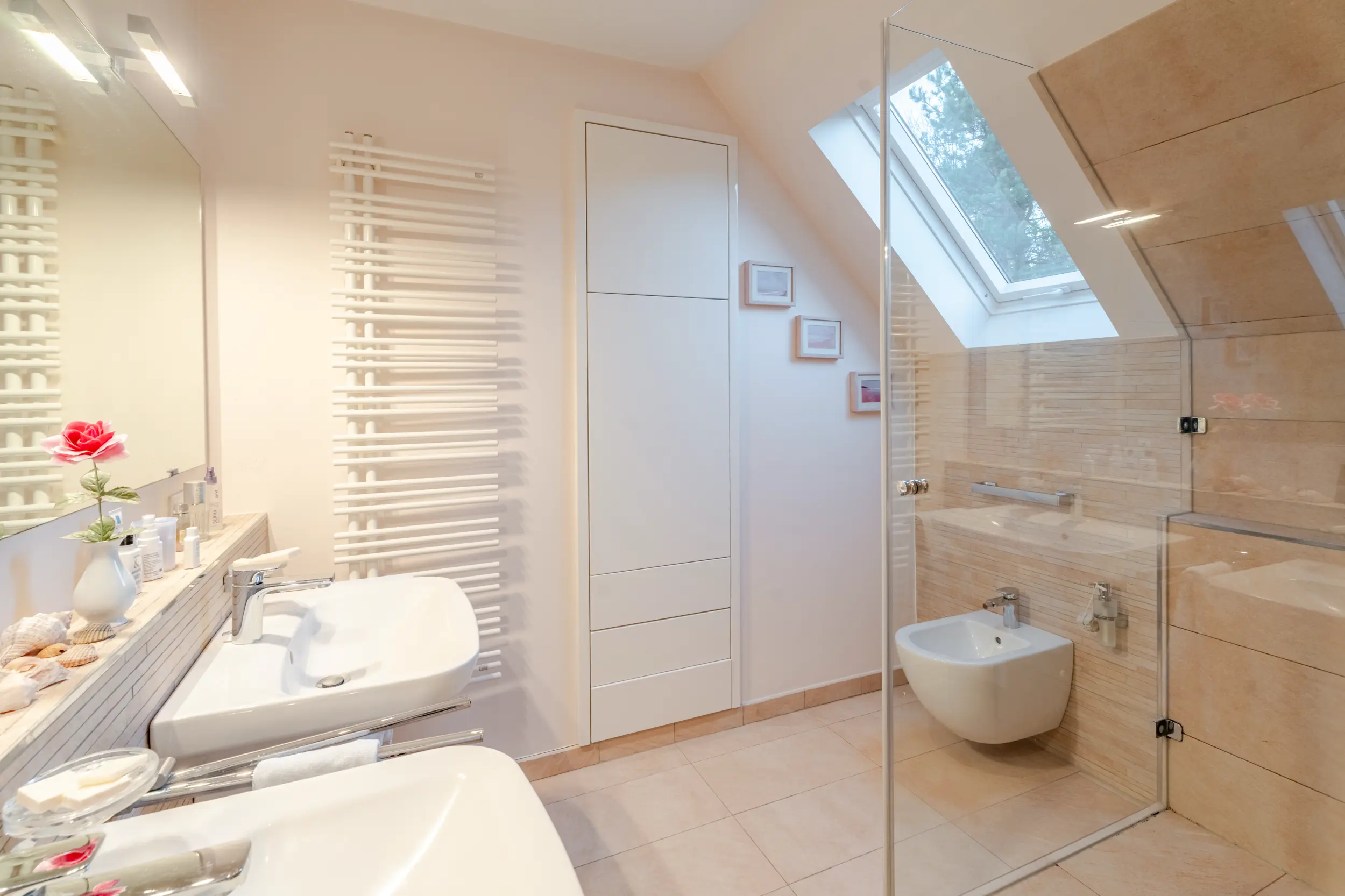 Helles Badezimmer im Einfamilienhaus mit Einliegerwohnung in Bad Bentheim, Dusche mit Glasabtrennung und Dachfenster.