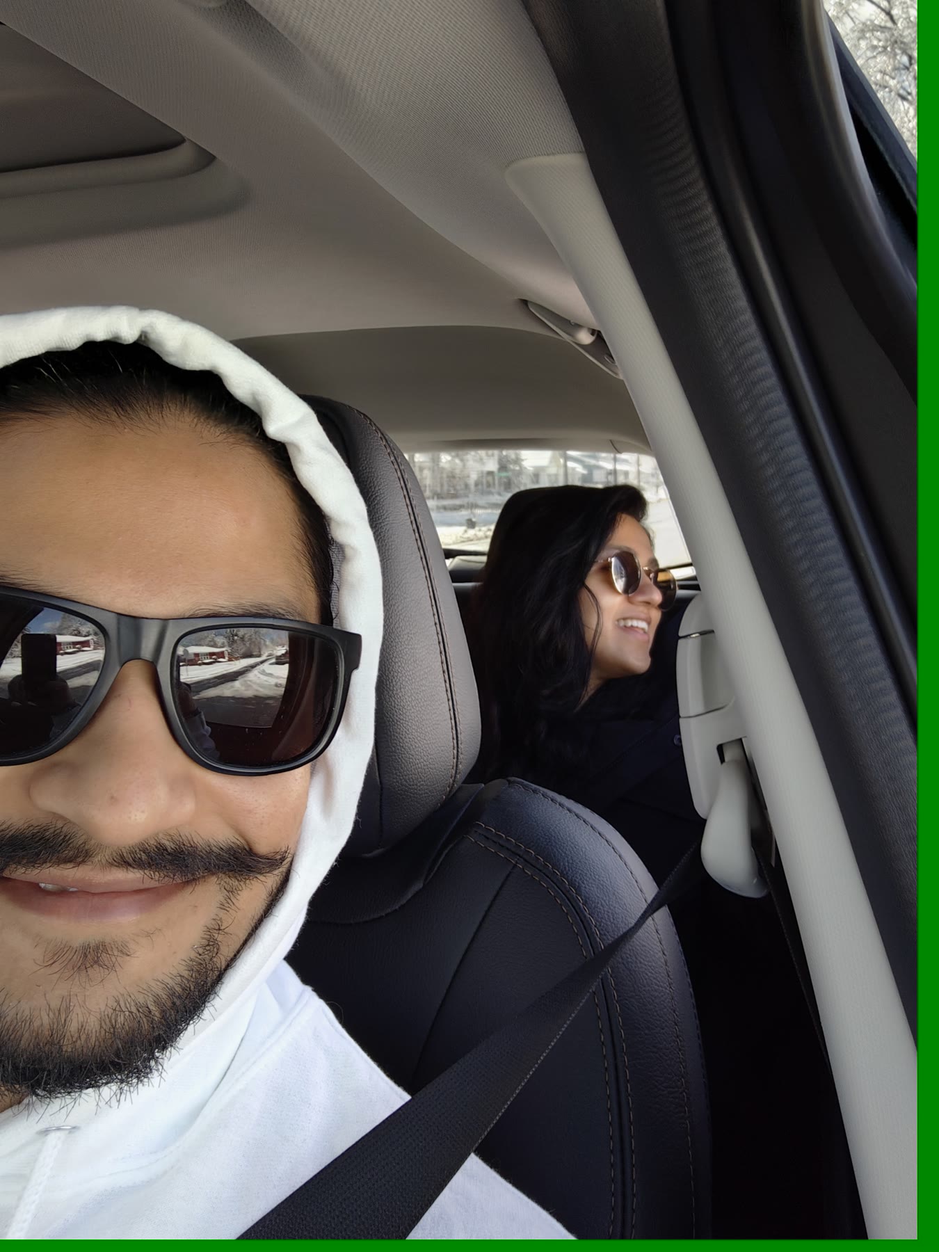 A snowy-day car selfie with Sarika laughing in the back seat