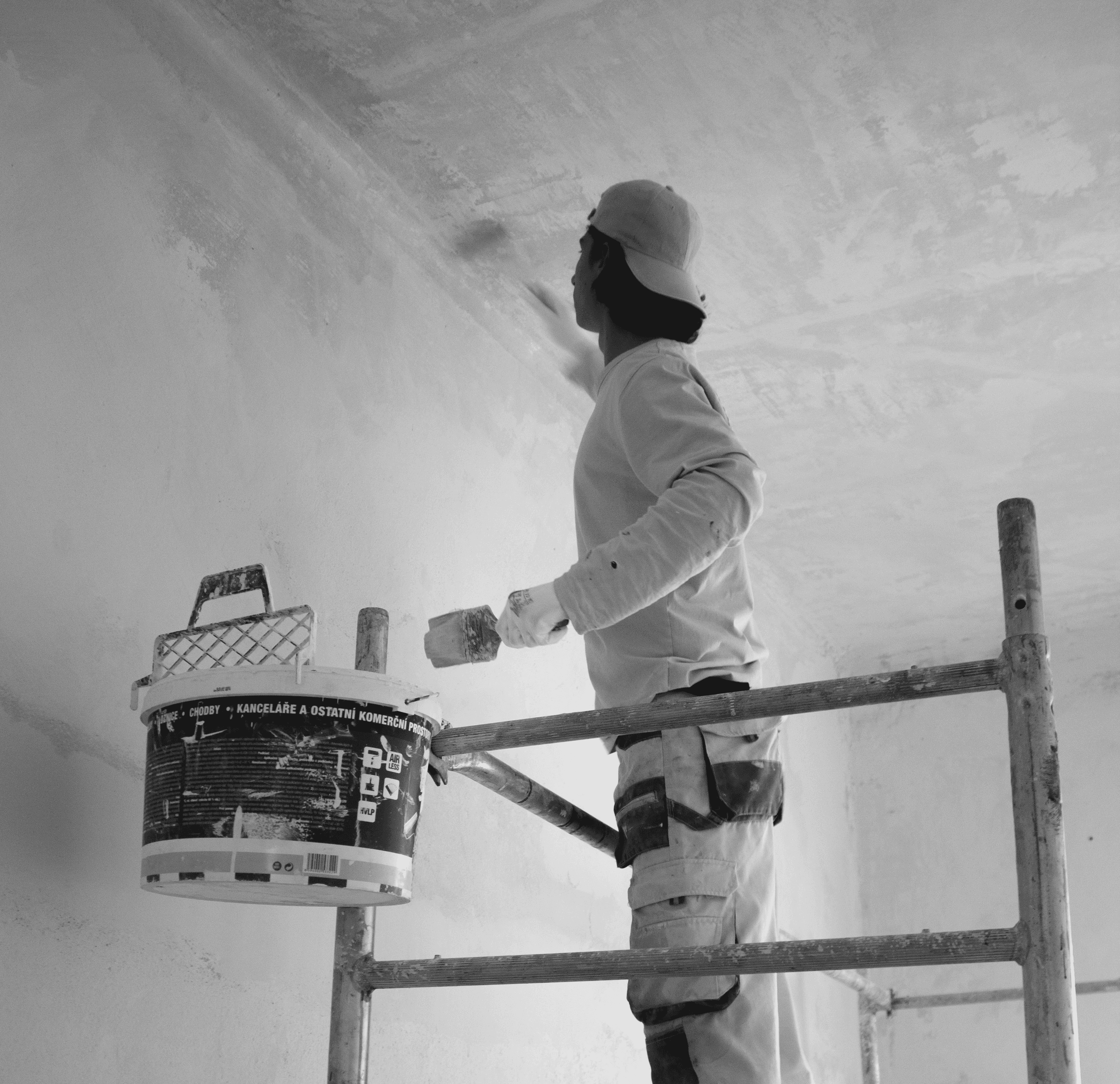 a man painting a wall with a paint roller
