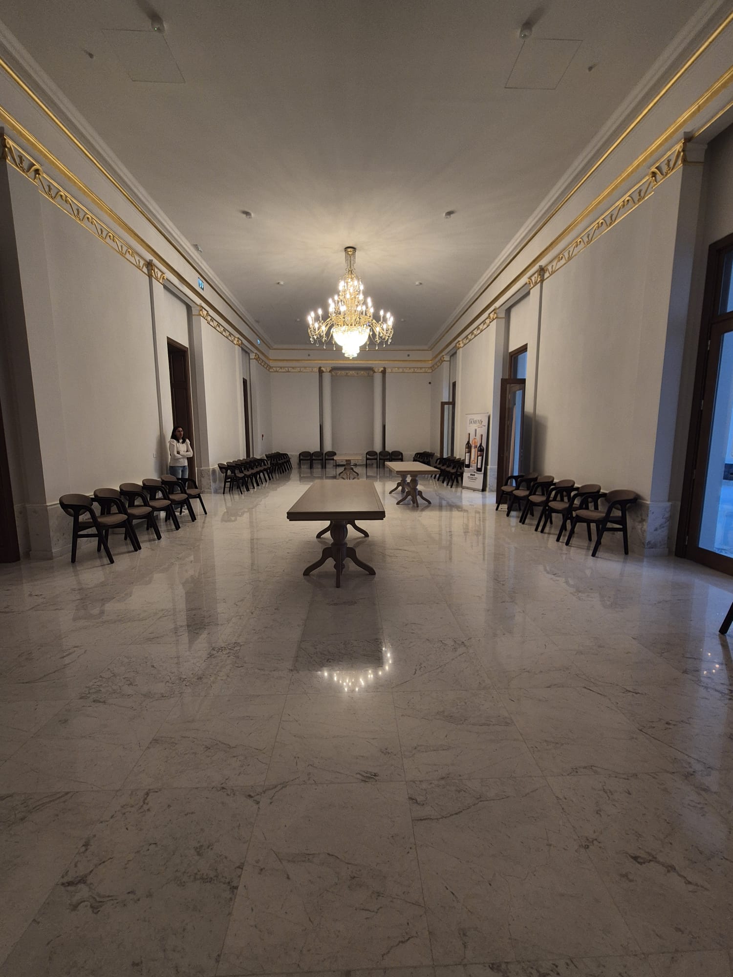 Smiling young man with short hair poses against a dark background, wearing a green button-up shirt.