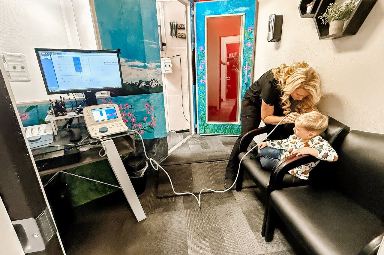 A close-up of a person receiving an ear cleaning, with hands gently handling their ear.