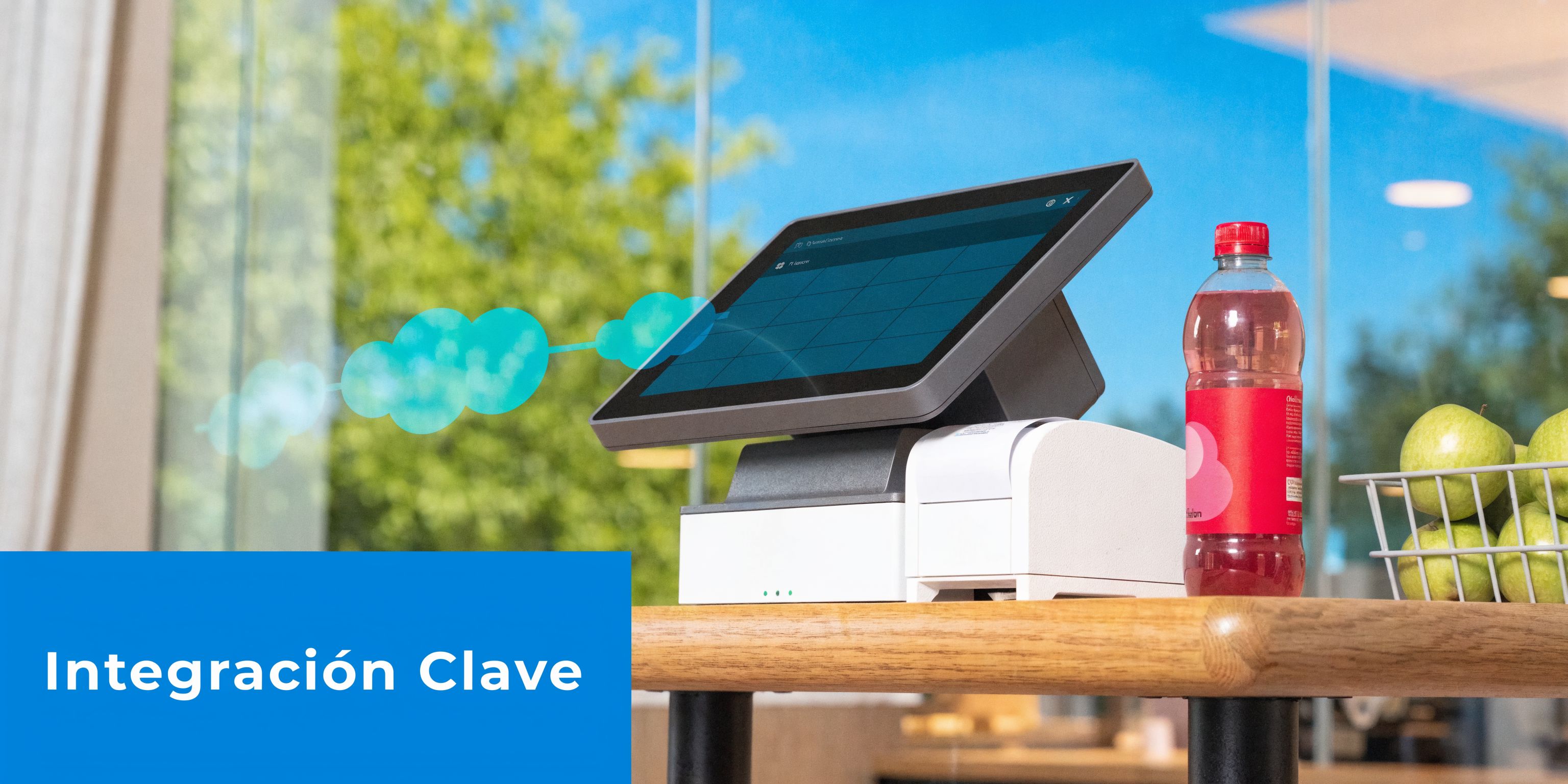 Punto de venta moderno en una mesa con una pantalla táctil, una botella de refresco y manzanas.