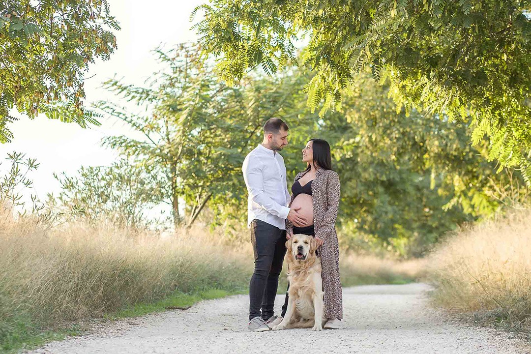 Chica embarazada junto a su pareja y su perro