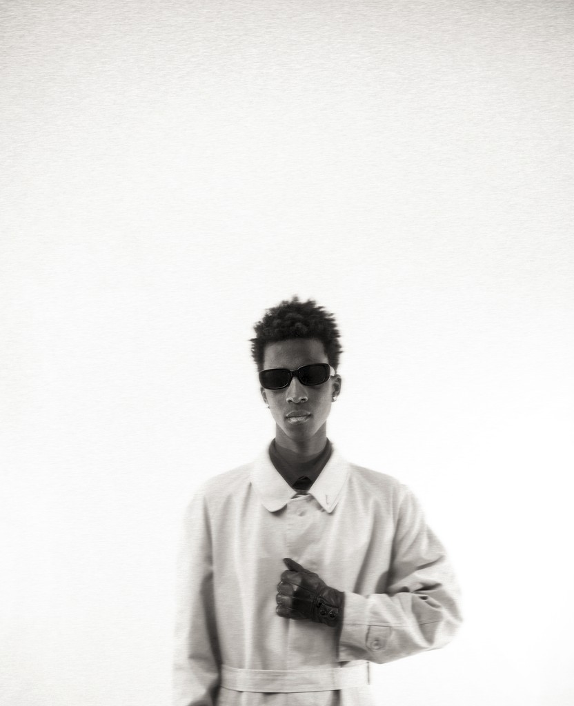 Elegant bride captured from behind holding a delicate bouquet of pastel roses — fine art wedding portrait in a serene garden. Élégante mariée photographiée de dos tenant un bouquet délicat de roses pastel — portrait de mariage artistique dans un jardin paisible.