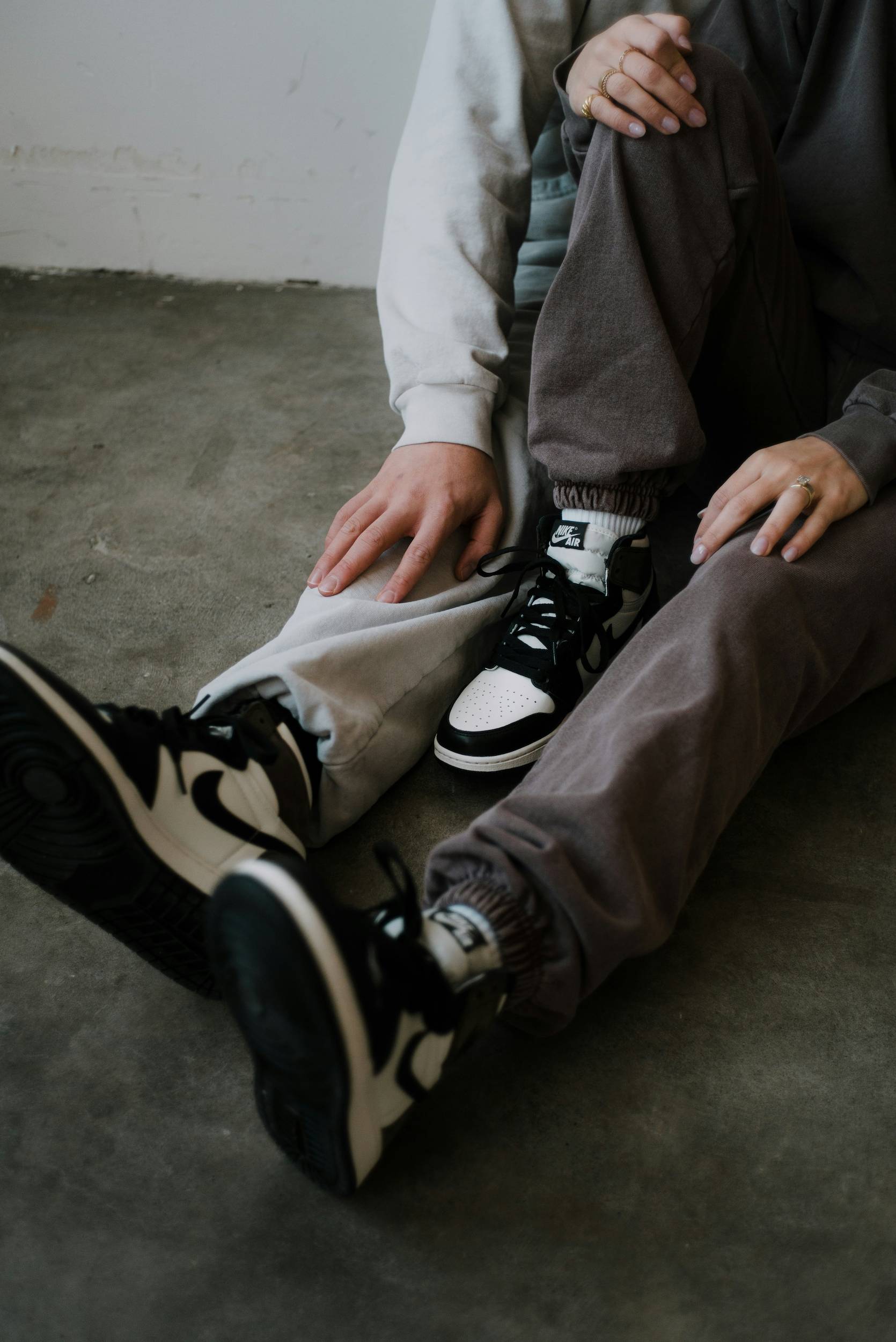 A couples legs showcasing high-top sneakers