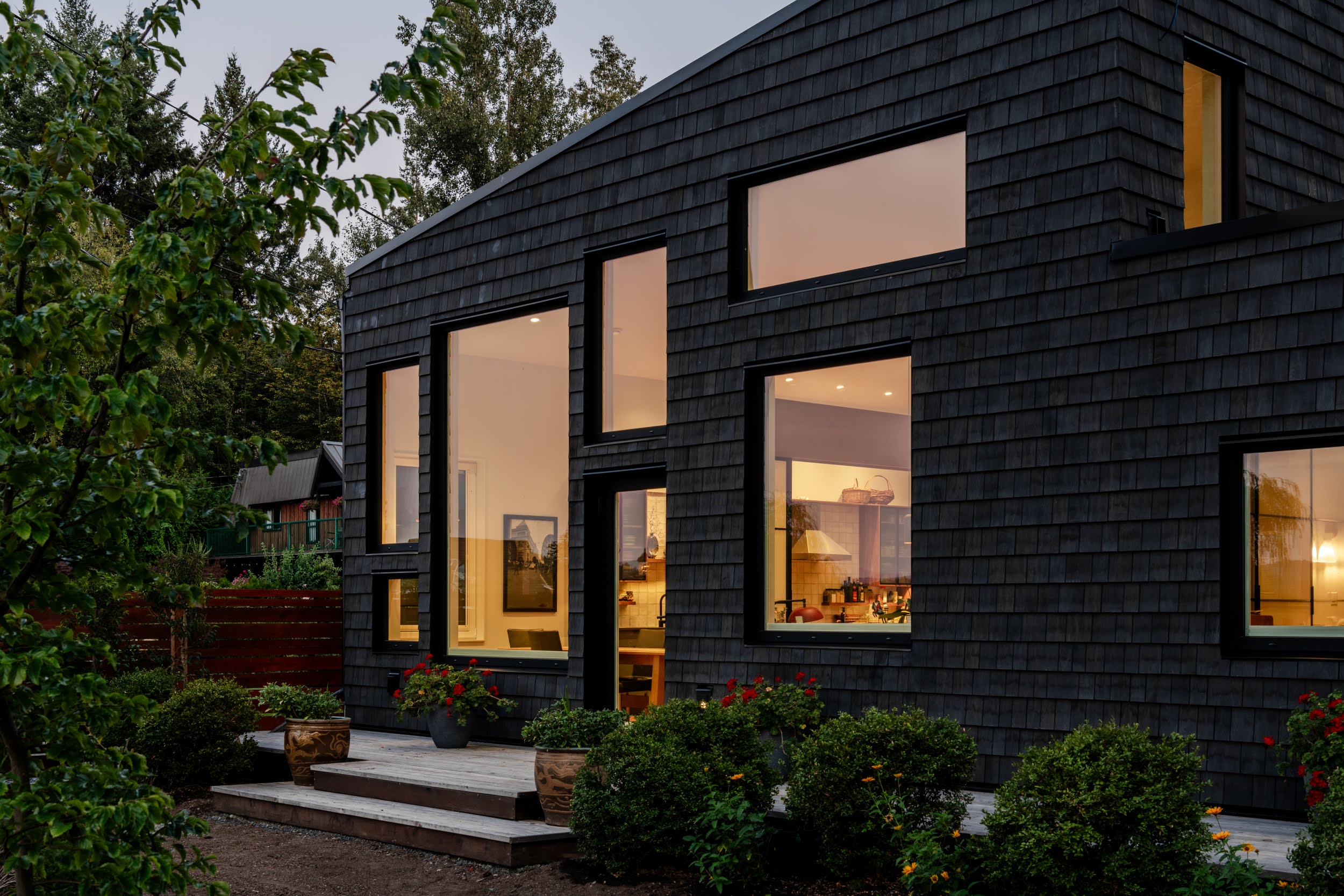Modern bathroom featuring wooden cabinetry, a bathtub, a sleek sink, and natural light from a window.